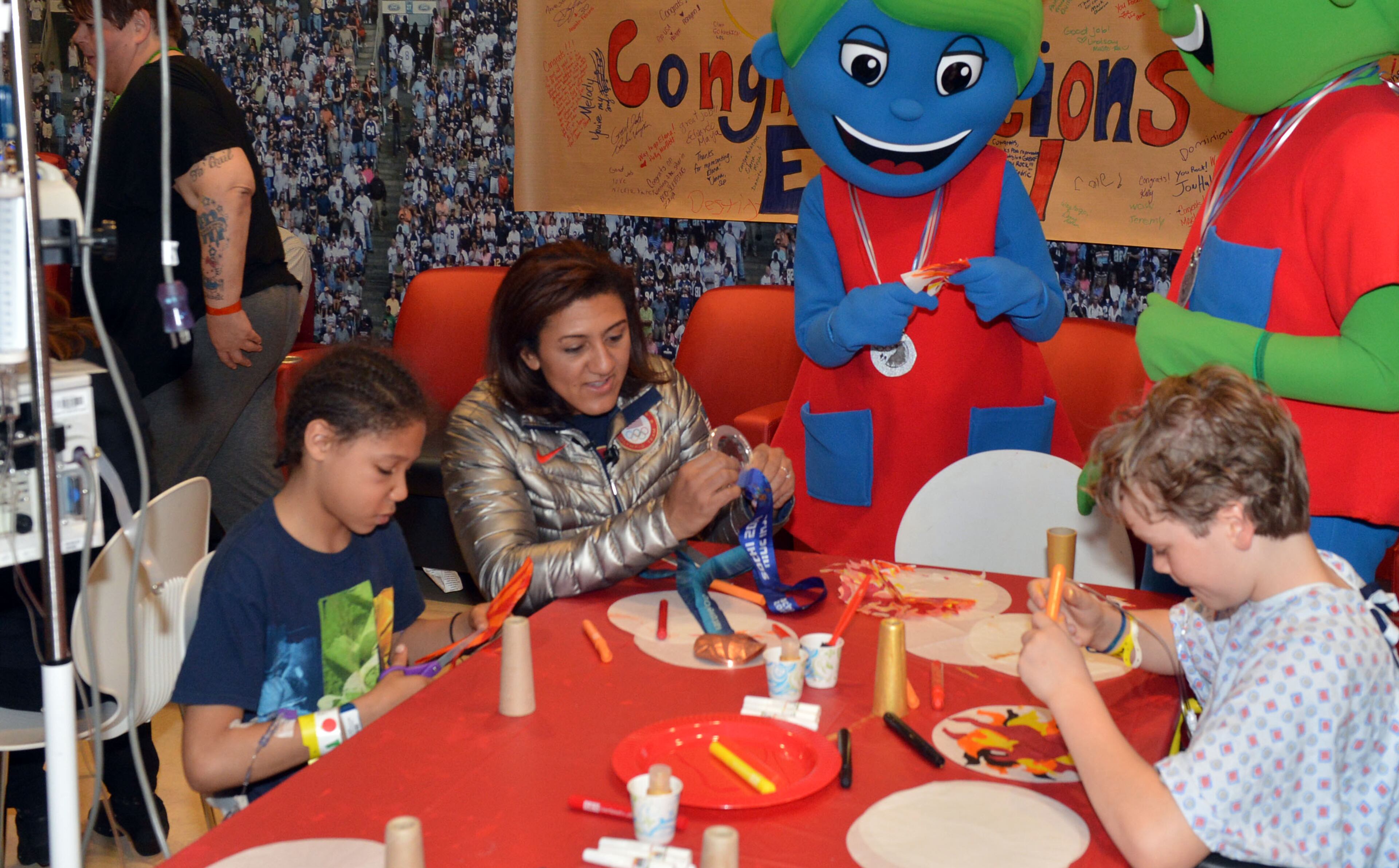 Elana Meyers talks with Jaquil Hall, 10 (left), of College Park, and Matthew Edson, 13, of Atlanta as she shared her silver medal from the Winter Olympic Games with patients during a visit to The Zone at Children's Healthcare of Atlanta at Scottish Rite. KENT D. JOHNSON / KDJOHNSON@AJC.COM