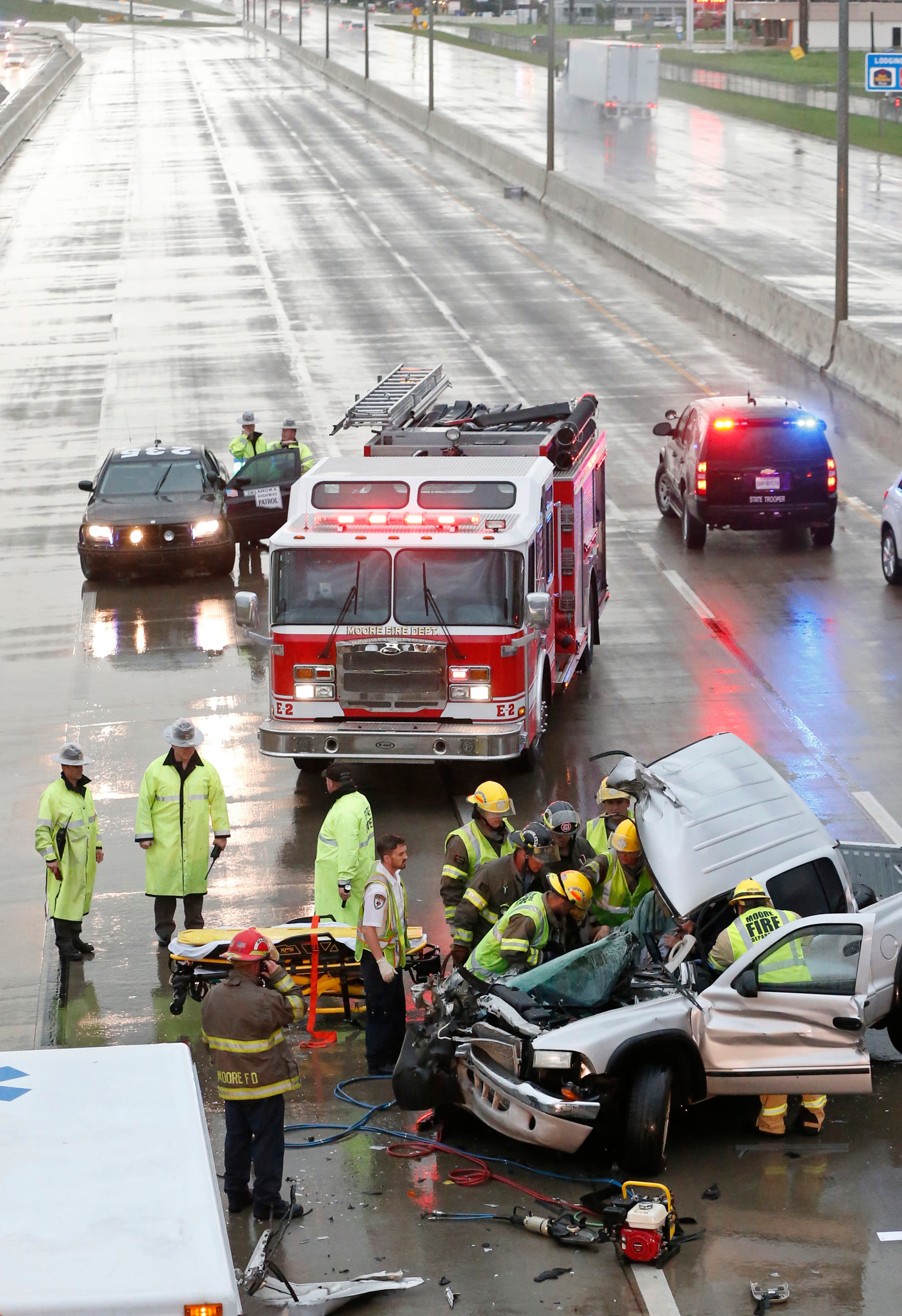 First responders work to remove a passenger of a truck involved in an accident on Interstate 35 during severe weather in Moore, Okla., on May 6, 2015. I-35 southbound is closed behind the accident.