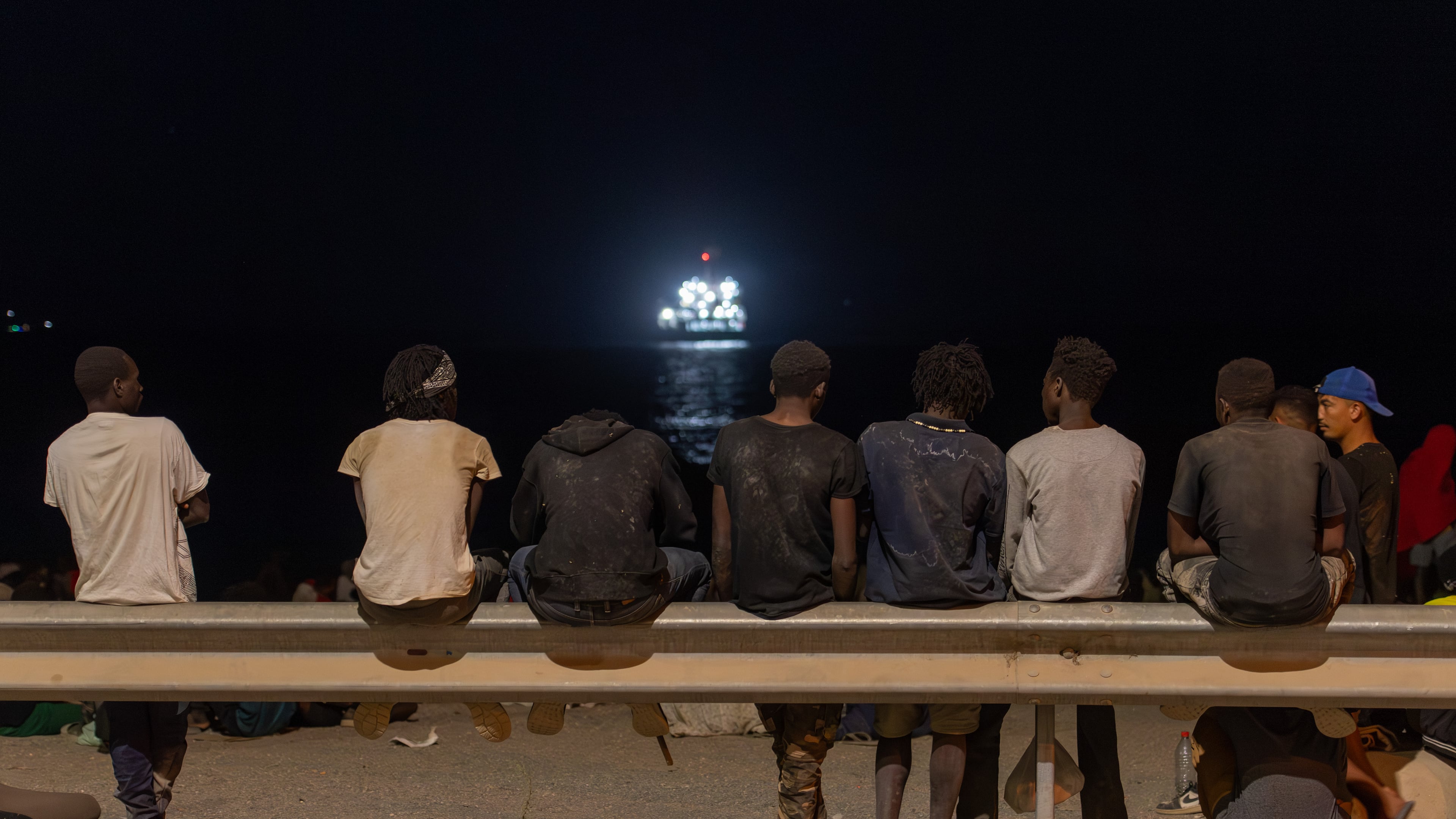 Migrants who crossed into Spain from Morocco gather on a beach in the Spanish enclave of Ceuta, Sunday, Aug. 2, 2026. (AP Photo/Antonio Sempere)
