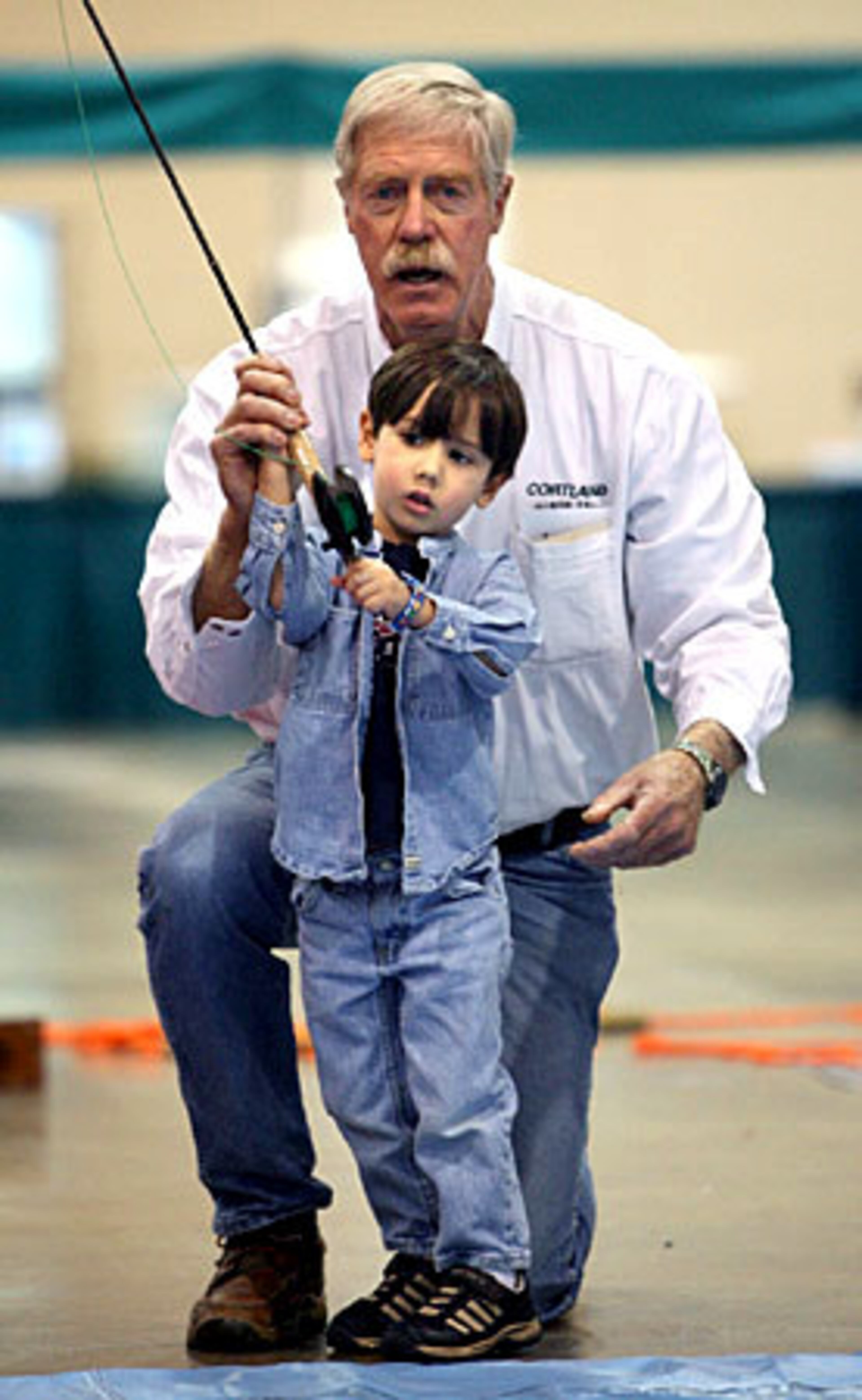 Rick Ruoff helps Reed Livingstong, 3, of Johns Creek, to learn how to cast during kids casting.