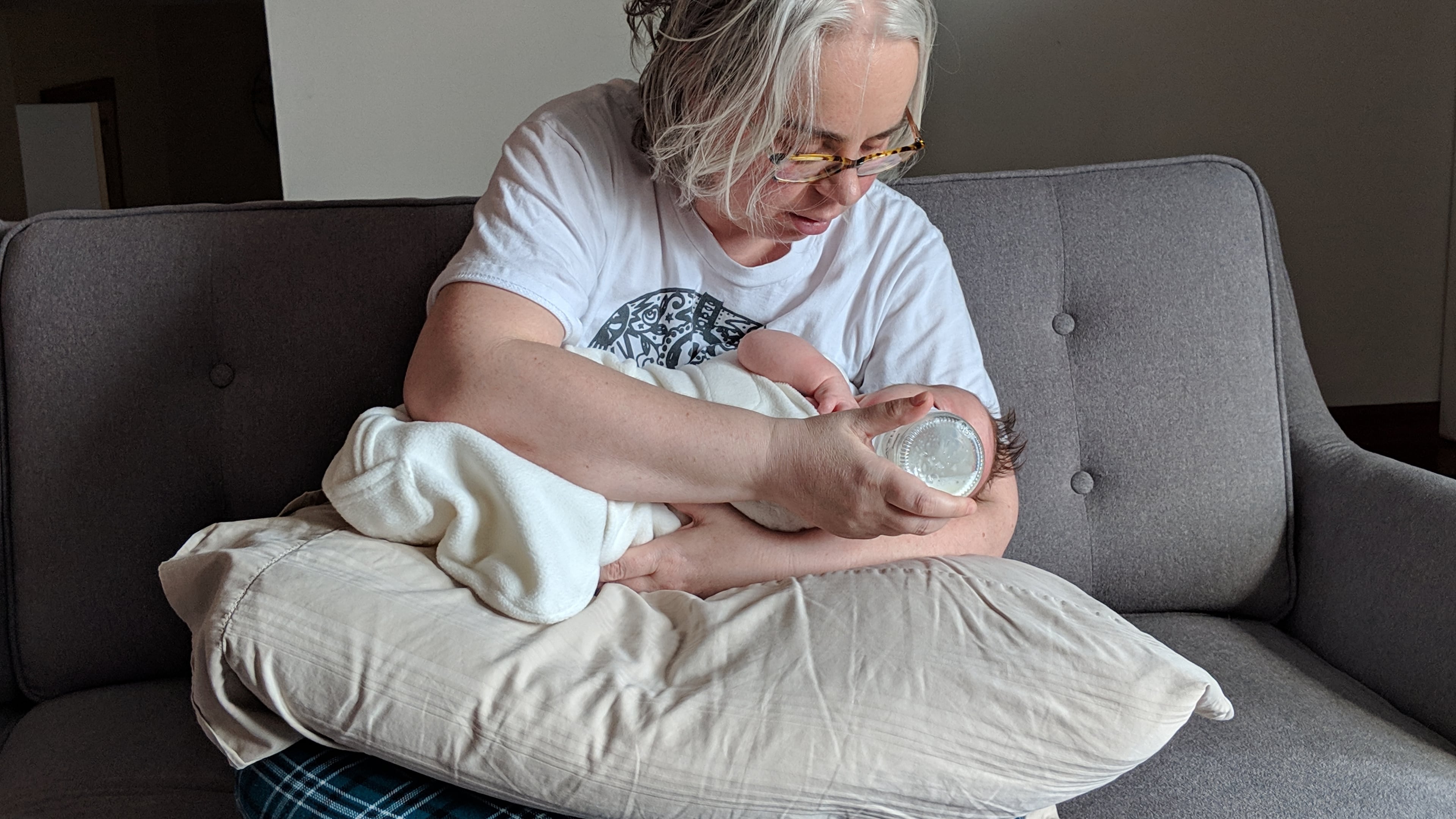 This photo provided by James Fitzsimmons shows Bridget María Chesterton cradling her infant daughter on her couch in Grand Island, N.Y., March 20, 2019. (James Fitzsimmons via AP)
