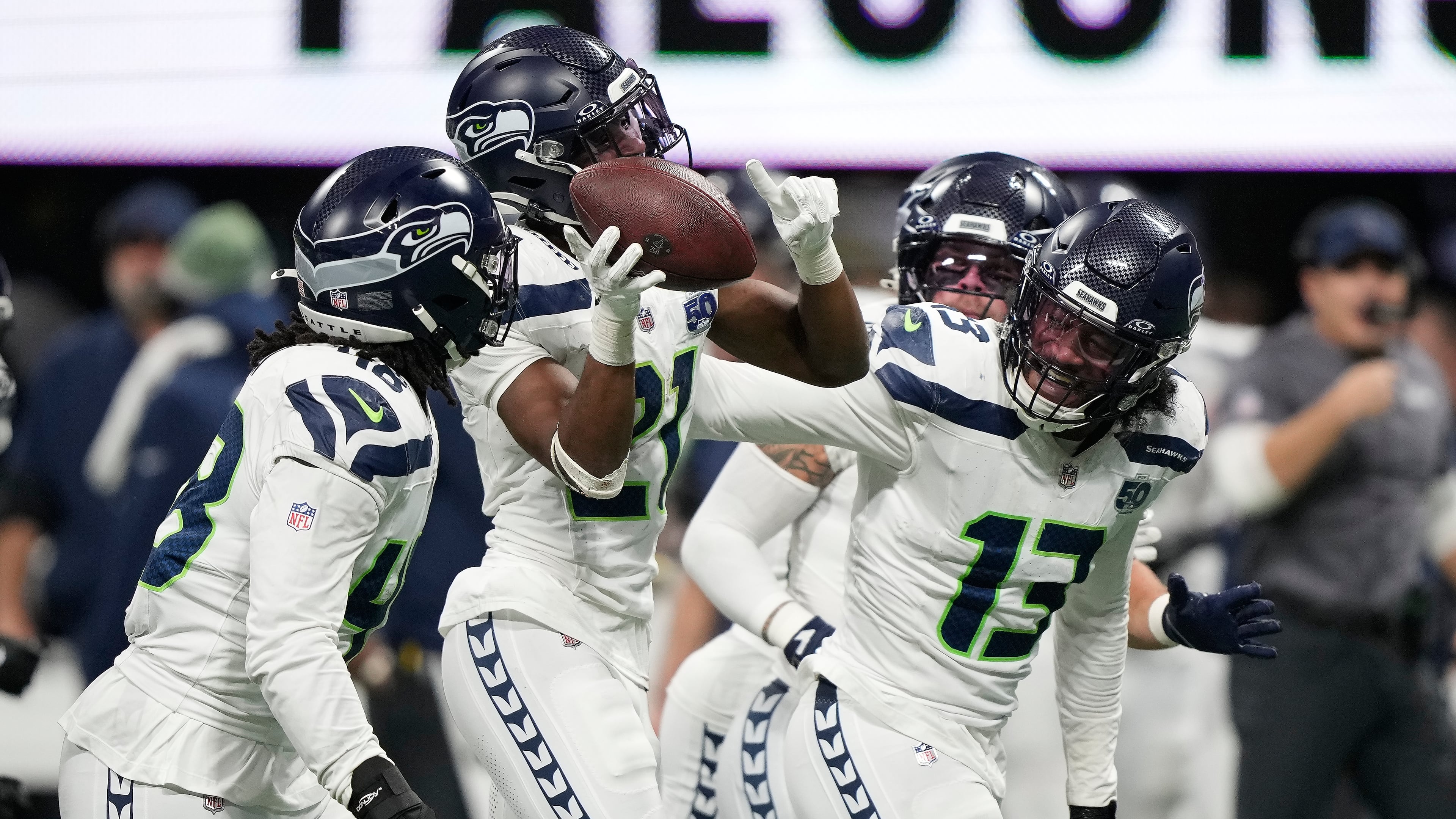 Seattle Seahawks cornerback Devon Witherspoon, second from left, celebrates his interception against the Atlanta Falcons with teammates Tyrice Knight, left, and Ernest Jones IV (13) during the second half of an NFL football game, Sunday, Dec. 7, 2025, in Atlanta. (Brynn AndersonAP)