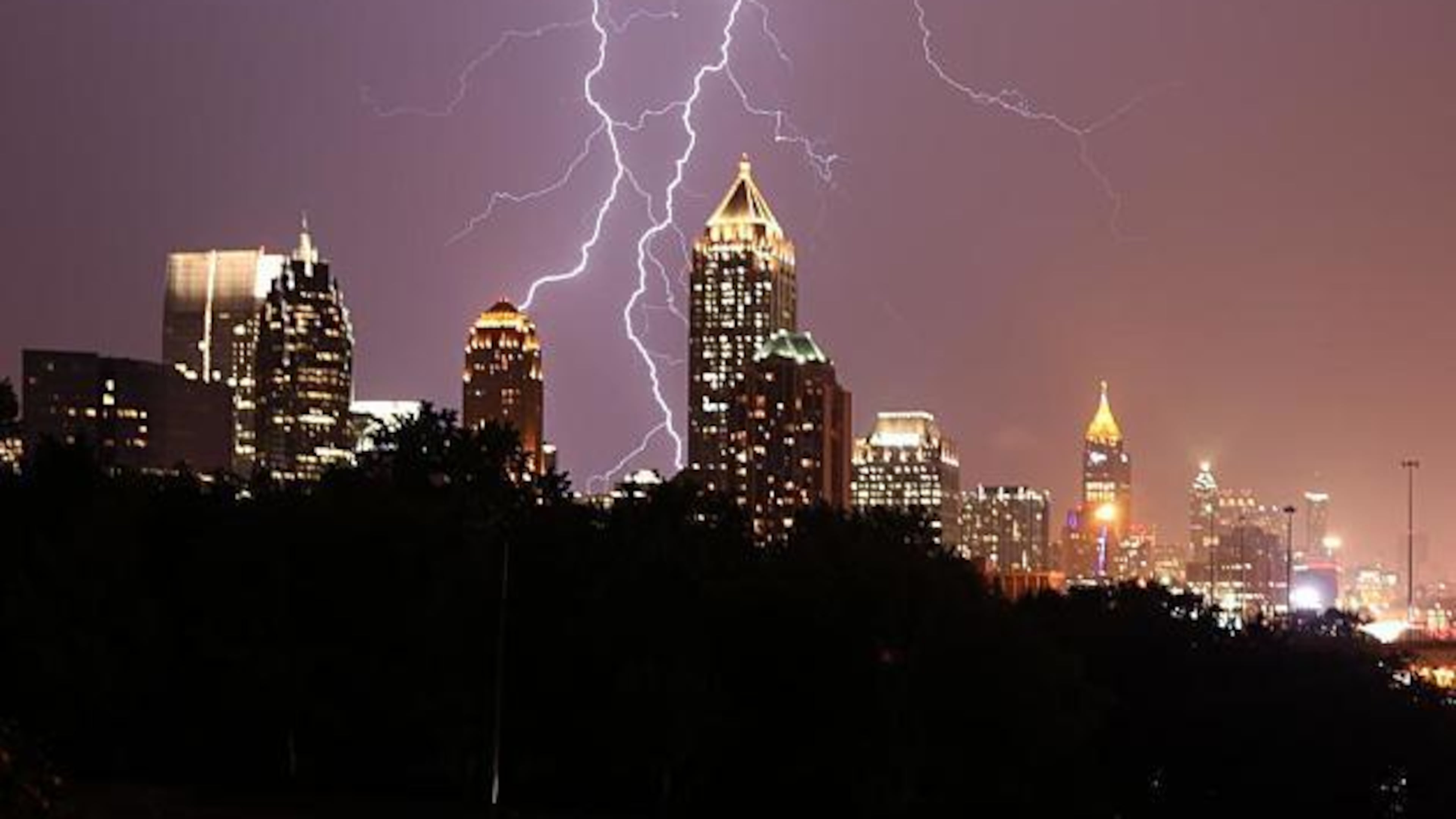 Lightning strikes behind the Atlanta skyline in a 2020 photo. A teenager swimming off Tybee Island is among the first two people killed by lightning this year in the U.S.