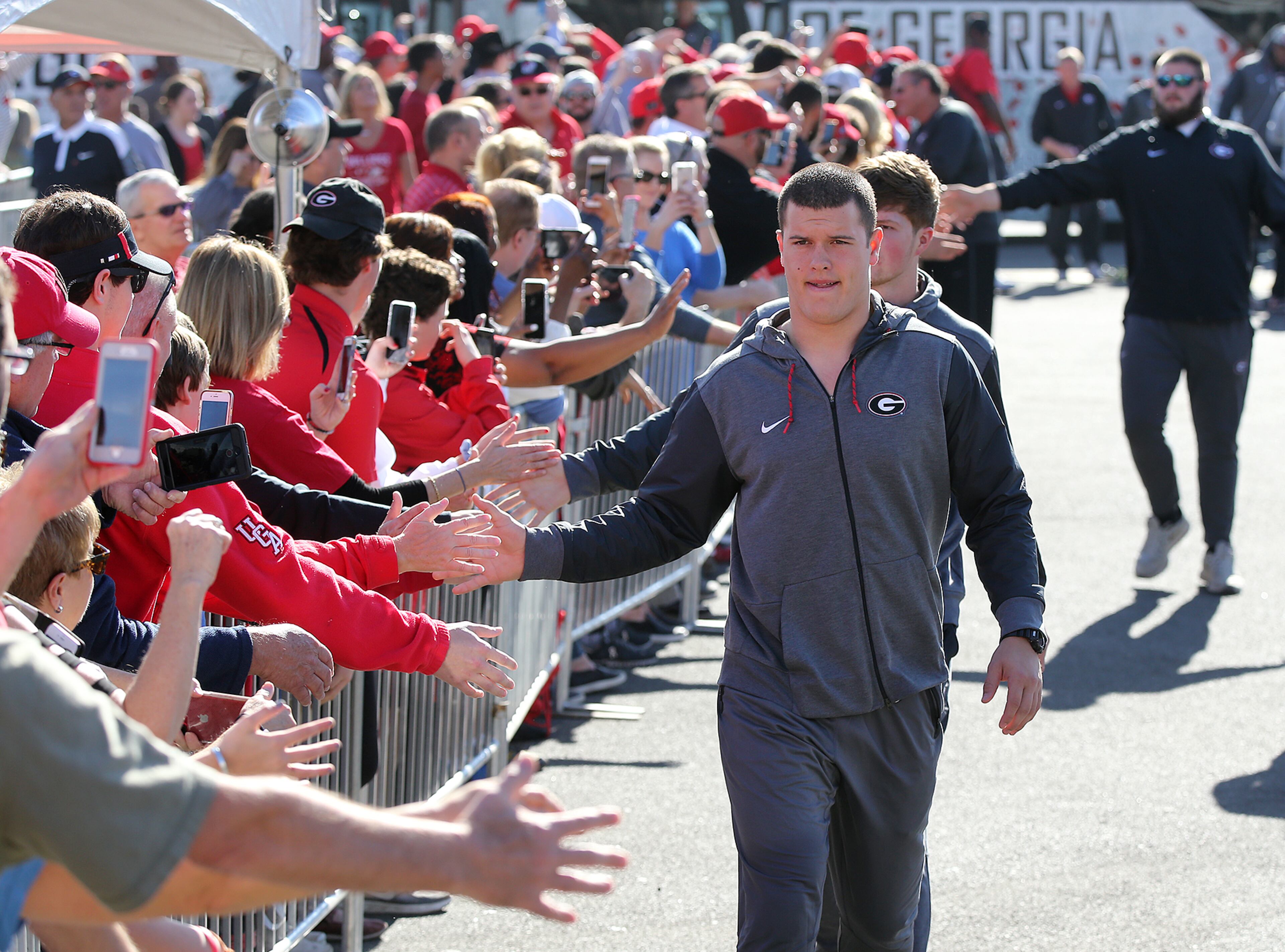 December 31, 2017 Pasadena: Georgia tight end Charlie Woerner gives hundreds of fans greeting the team five upon arriving on buses for the official team photo at Rose Bowl Stadium on Sunday, December 31, 2017, in Pasadena. Curtis Compton/ccompton@ajc.com