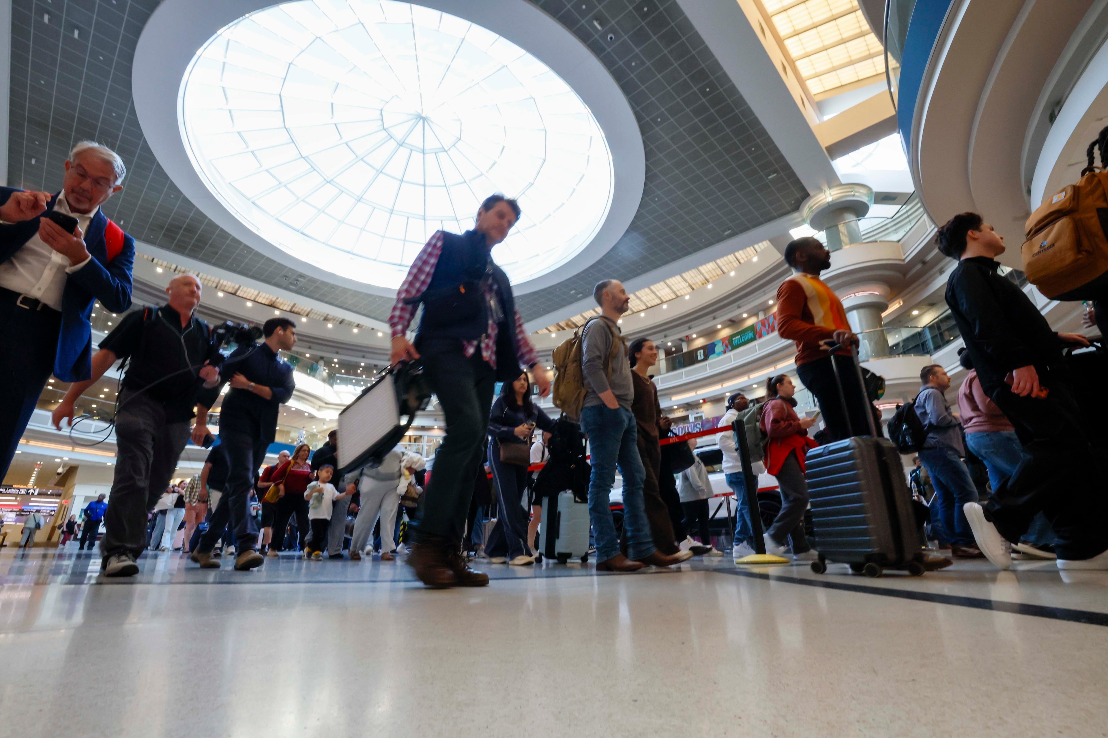 Travelers line up at the atrium approaching the Main checkpoint for security screening early Monday morning at Hartsfield-Jackson Atlanta International Airport on March 23, 2026. (Miguel Martinez/AJC)