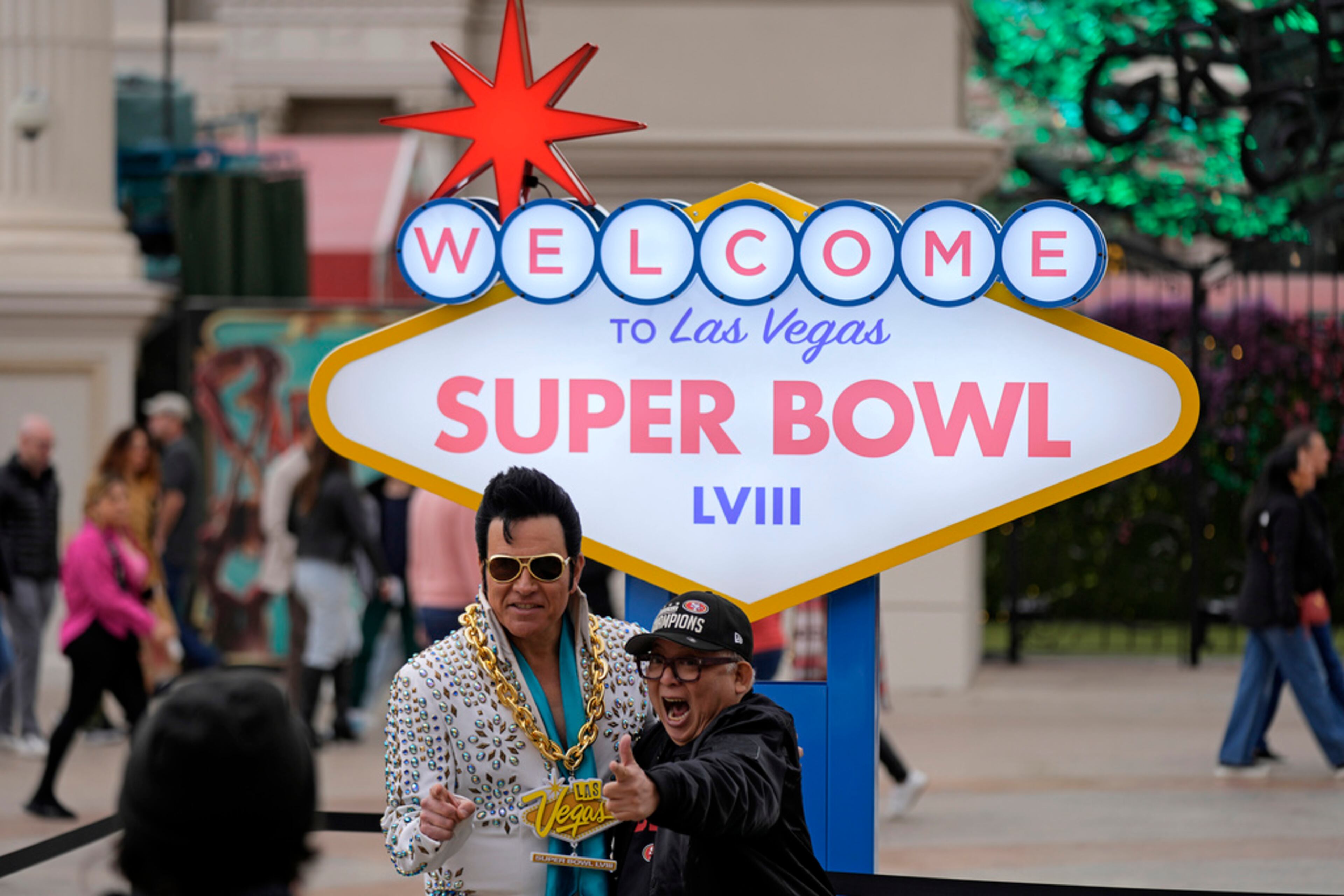 A San Francisco 49ers fan has his photo taken with an Elvis impersonator in front of a Super Bowl 58 sign at Caesars Palace Friday, Feb. 9, 2024 in Las Vegas. The Kansas City Chiefs will play the NFL football game against the San Francisco 49ers Sunday. (AP Photo/Charlie Riedel)