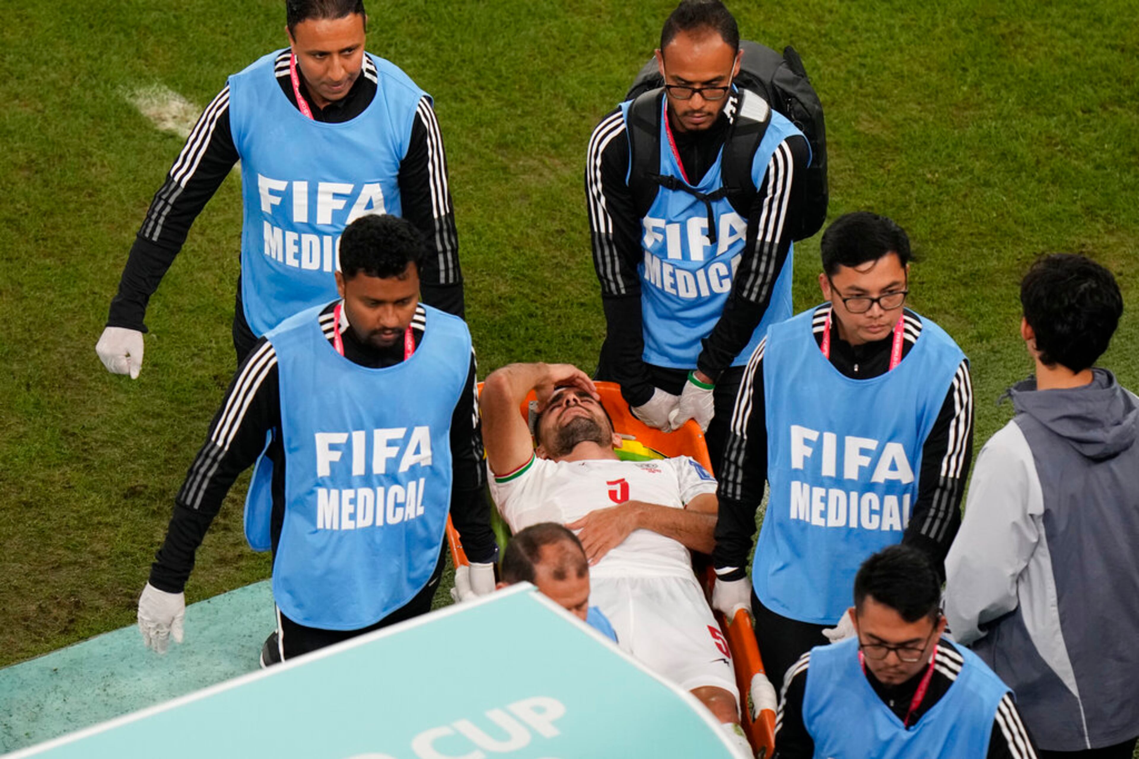 Iran's Milad Mohammadi is carried by medical staff during the World Cup group B soccer match between Iran and the United States at the Al Thumama Stadium in Doha, Qatar, Tuesday, Nov. 29, 2022. (AP Photo/Luca Bruno)