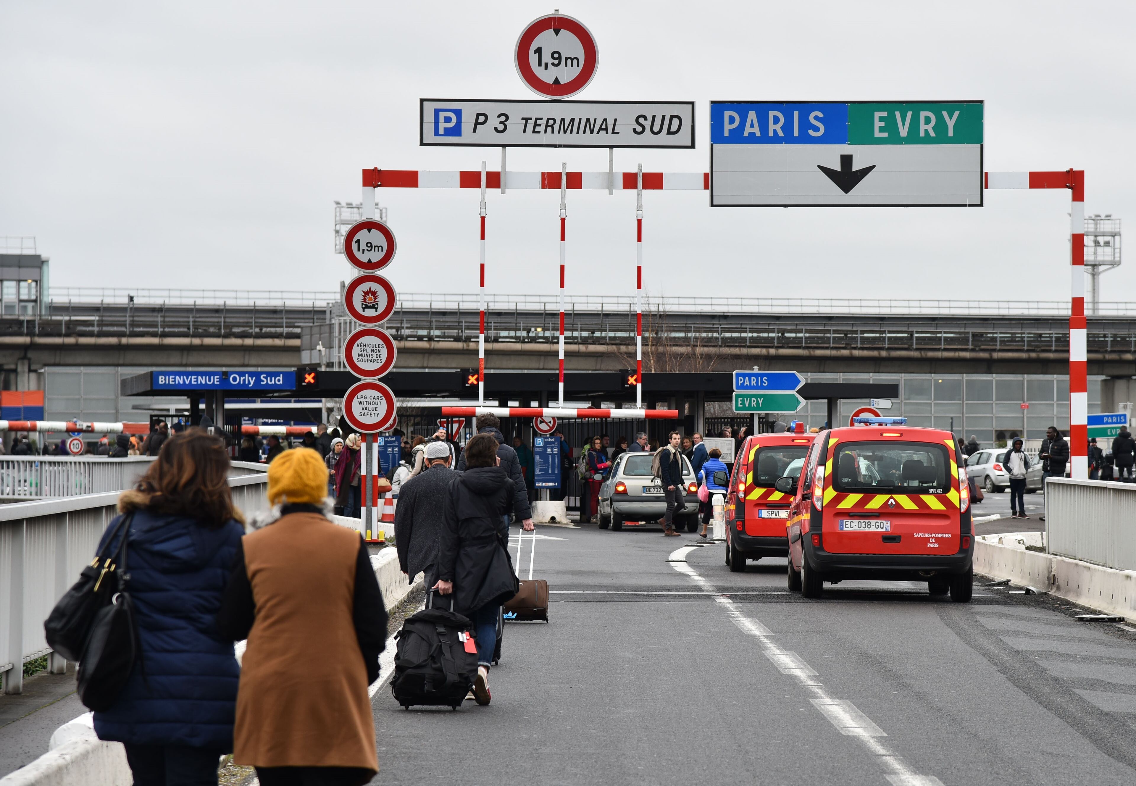Passengers evacuated from Orly airport walk on the highway at Orly airport, near Paris, France, following the shooting of a man by French security forces.