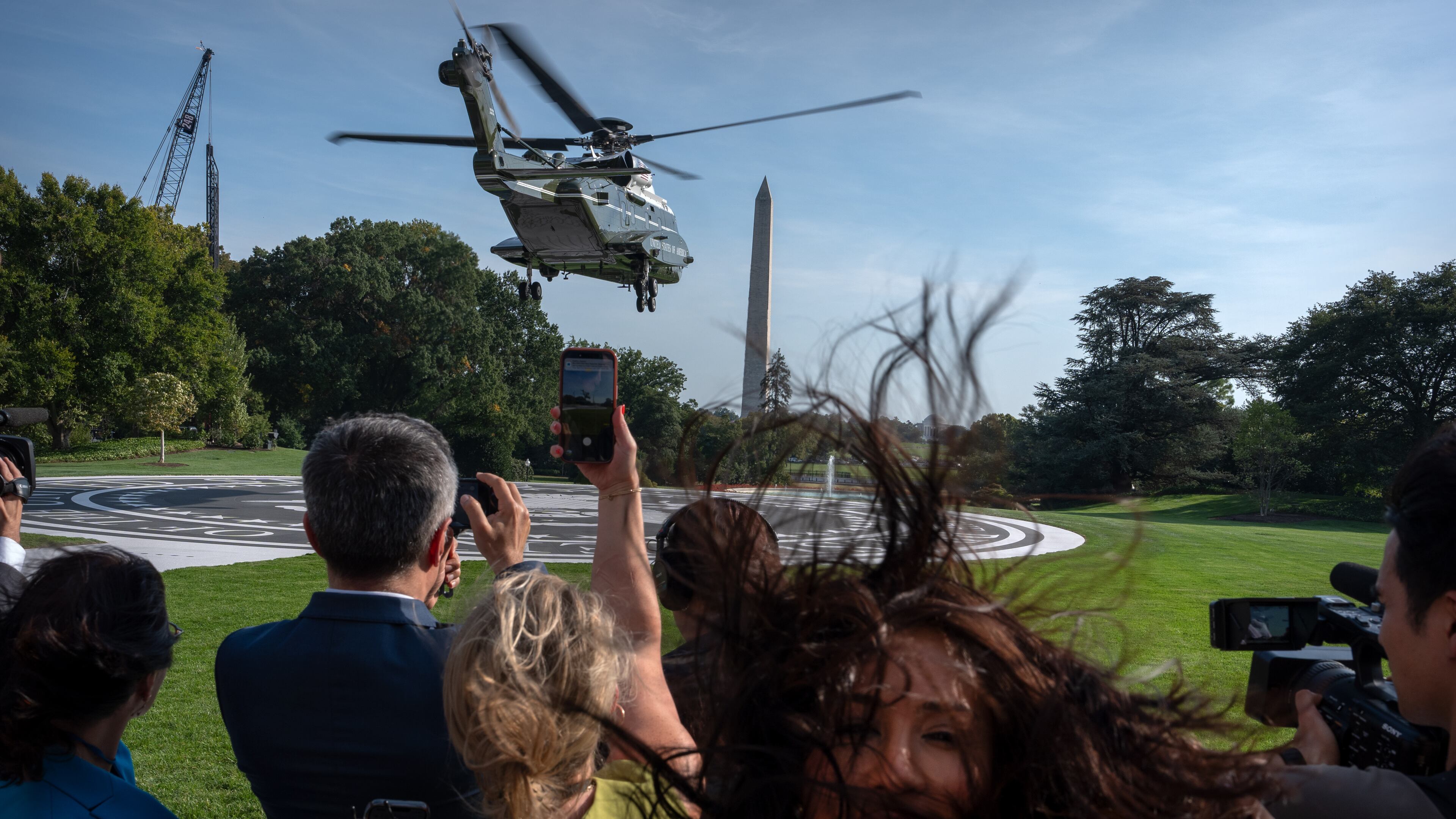 Members of the press watch as Marine One with President Donald Trump aboard lifts off from the South Lawn of the White House, Friday, Oct. 2, 2026, in Washington. (AP Photo/Mark Schiefelbein)