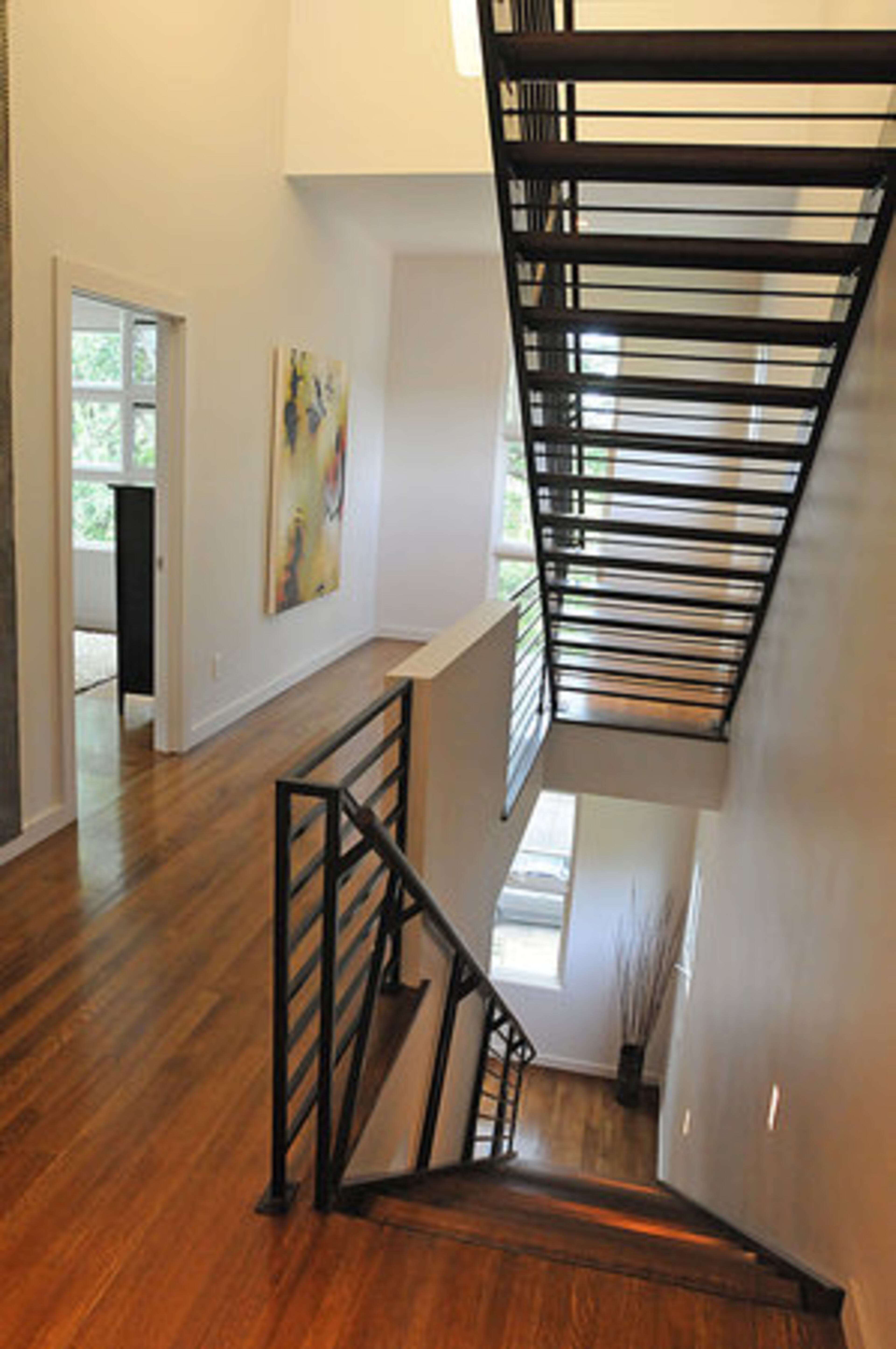The open floor plan continues upstairs. The design of the stairwell allows natural light to flow between the steps. Strategically placed windows take full advantage of the lush greenery outside that envelops the home.