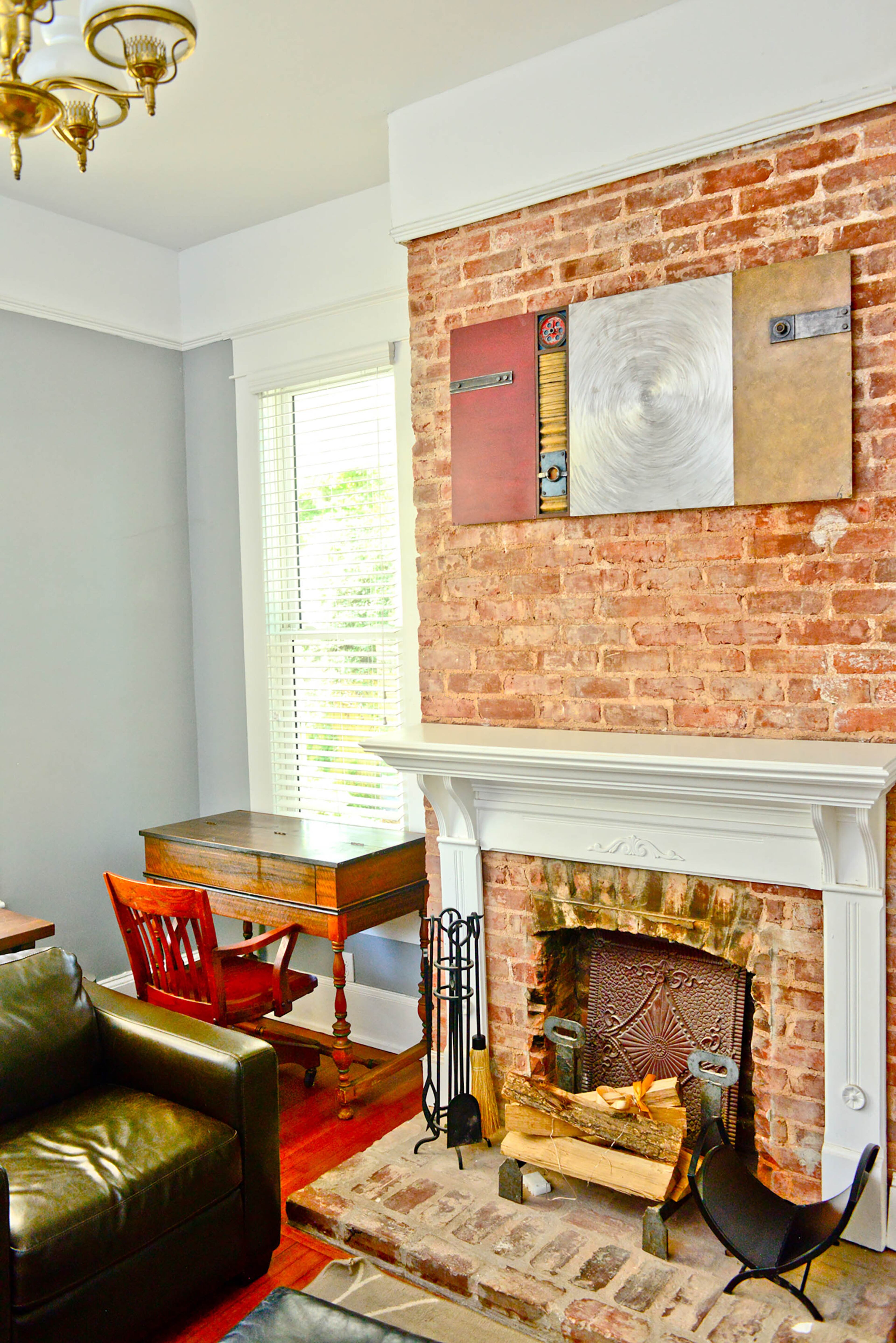 The couple's first real art purchase, a piece they bought from an artist at the Dogwood Festival, hangs in the home office. "We liked the soft and hard interplay of the mixed metals," Amanda Pellerin said. The desk is an antique from Philippe Pellerin's mother.