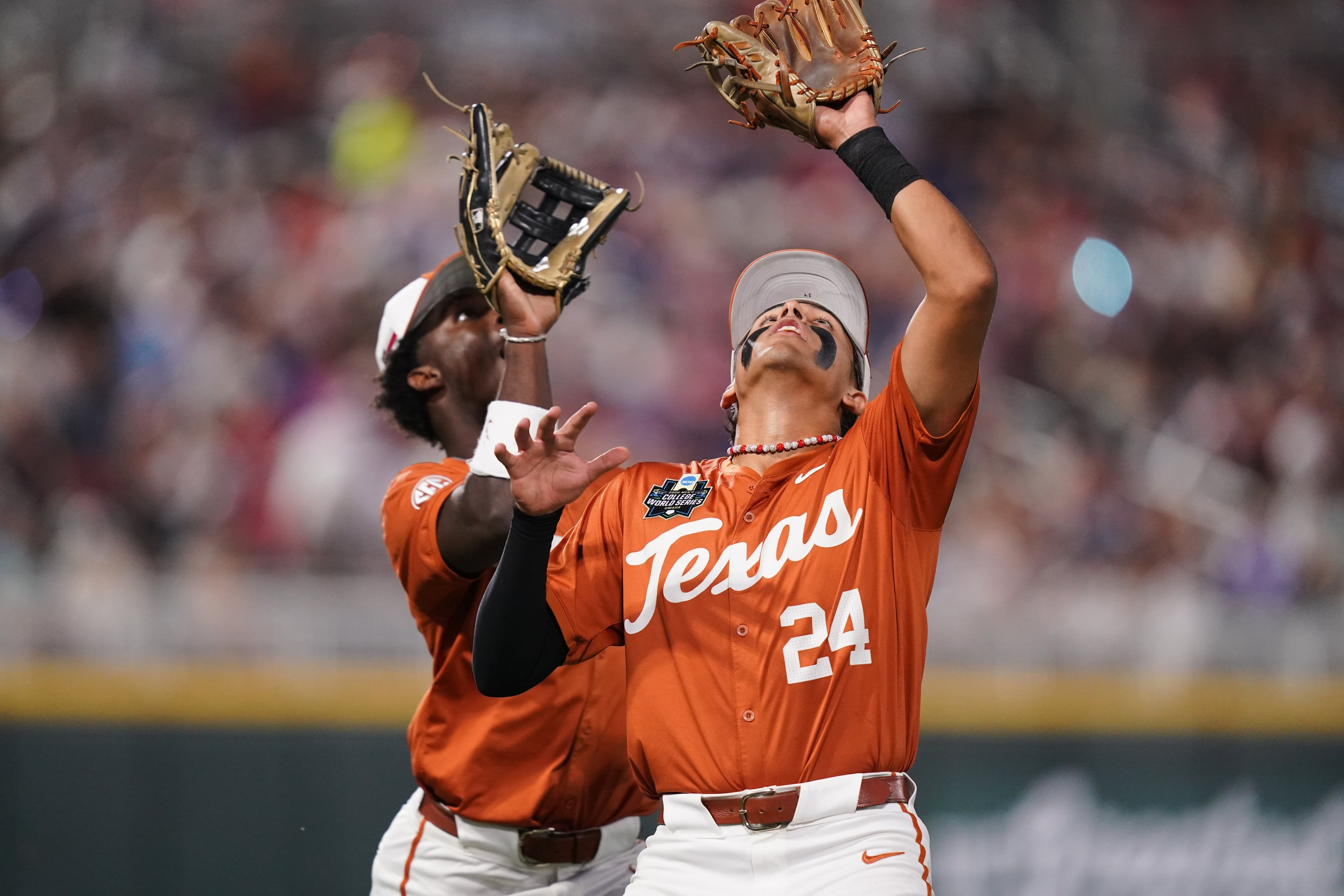 Texas infielder Adrian Rodriguez (24) makes the catch while colliding with outfielder Anthony Pack Jr. (6) during an NCAA baseball College World Series elimination game against Georgia, Tuesday, June 16, 2026 in Omaha, Neb. Georgia won 2-0. (AP Photo/Vera Nieuwenhuis)