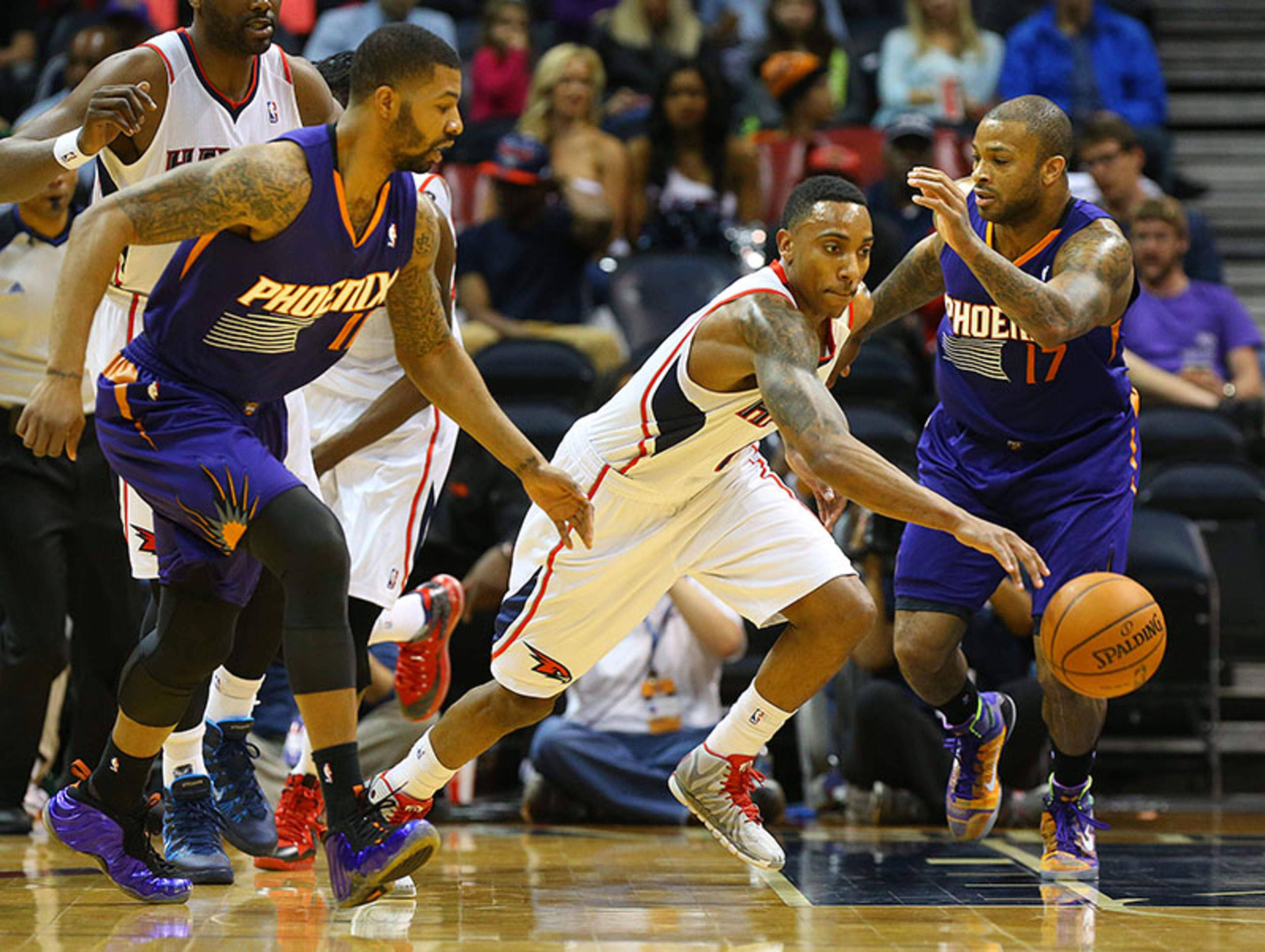 Hawks guard Jeff Teague cuts a lane between the Suns' Markieff Morris (left) and P.J. Tucker after stealing the ball.