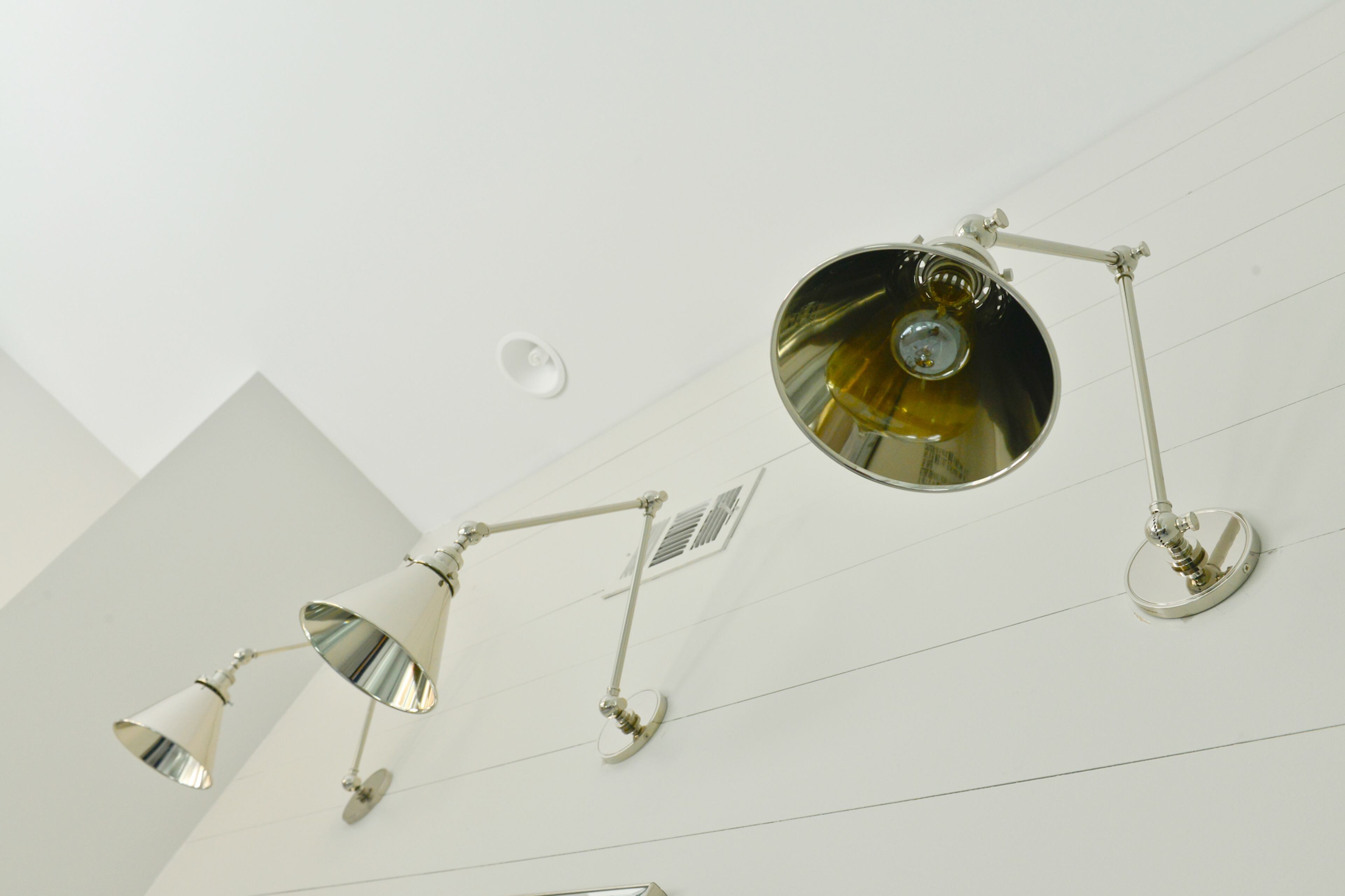 Sconces from RH Outlet illuminate the master bathroom and stand out against the shiplap walls, painted in Sherwin-Williams Repose Gray.