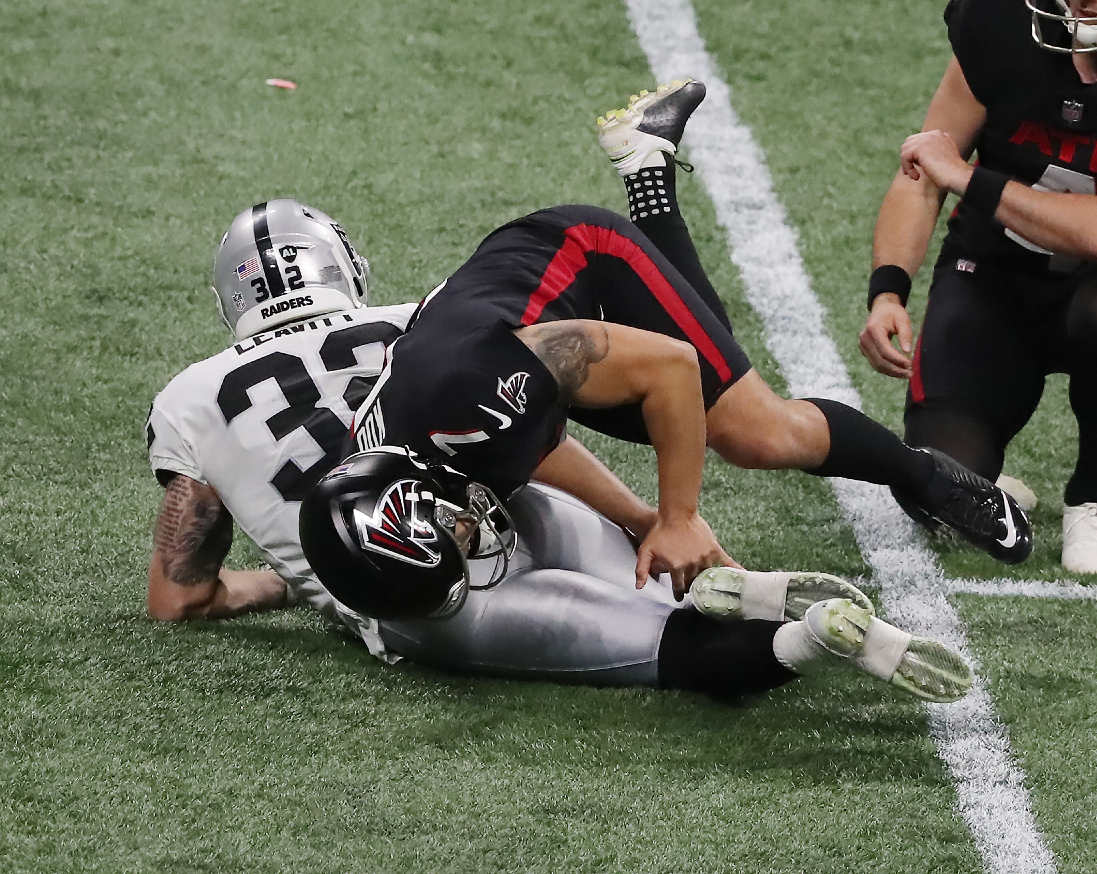 Las Vegas Raiders safety Dallin Leavitt is called for roughing the kicker rolling up on Atlanta Falcons kicker Younghoe Koo on a field goal attempt during the second quarter Sunday, Nov. 29, 2020, at Mercedes-Benz Stadium in Atlanta. (Curtis Compton / Curtis.Compton@ajc.com)