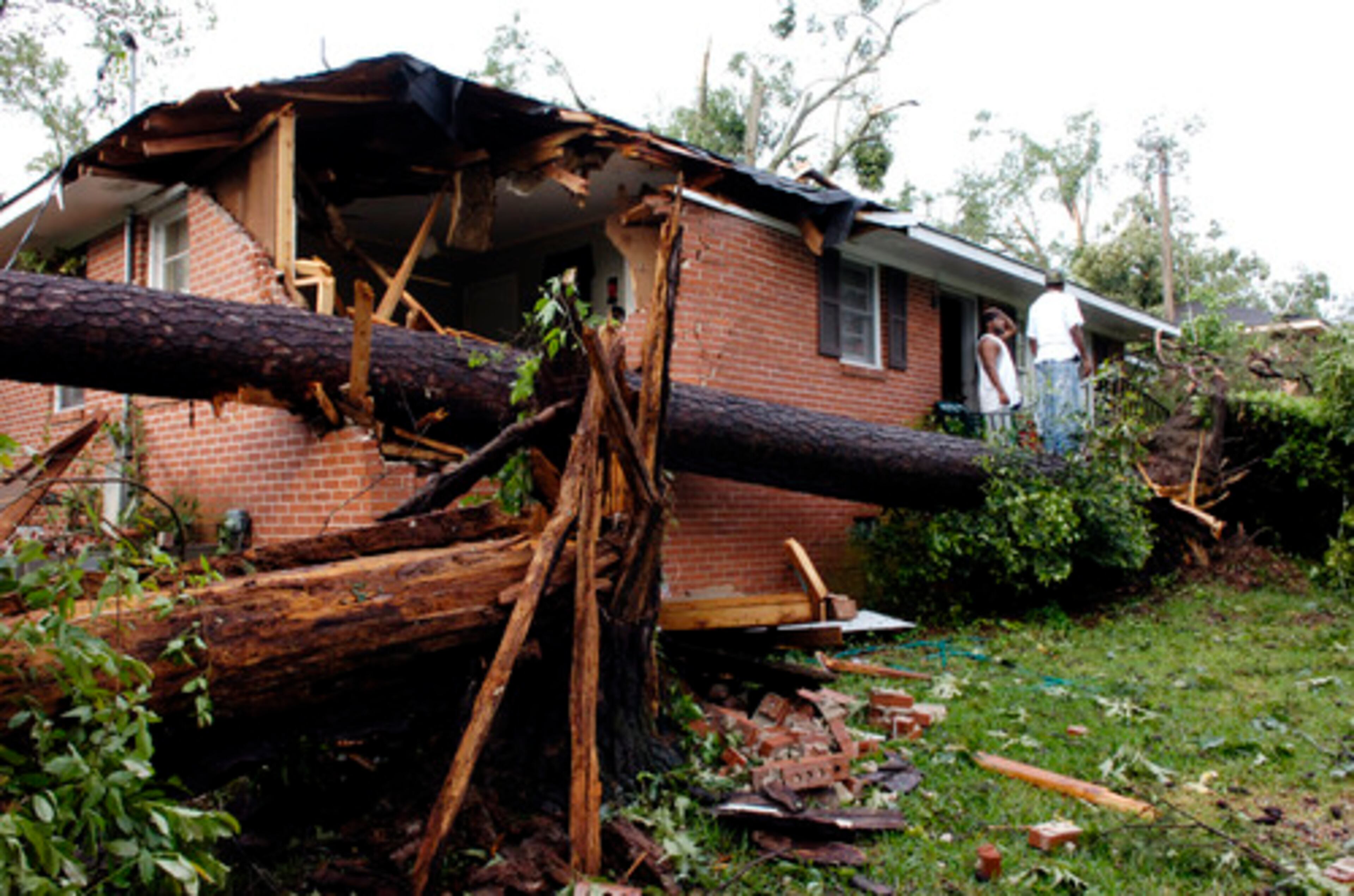 Mark Samples and Taveres Hardnett look at damage at Samples' home in Macon.