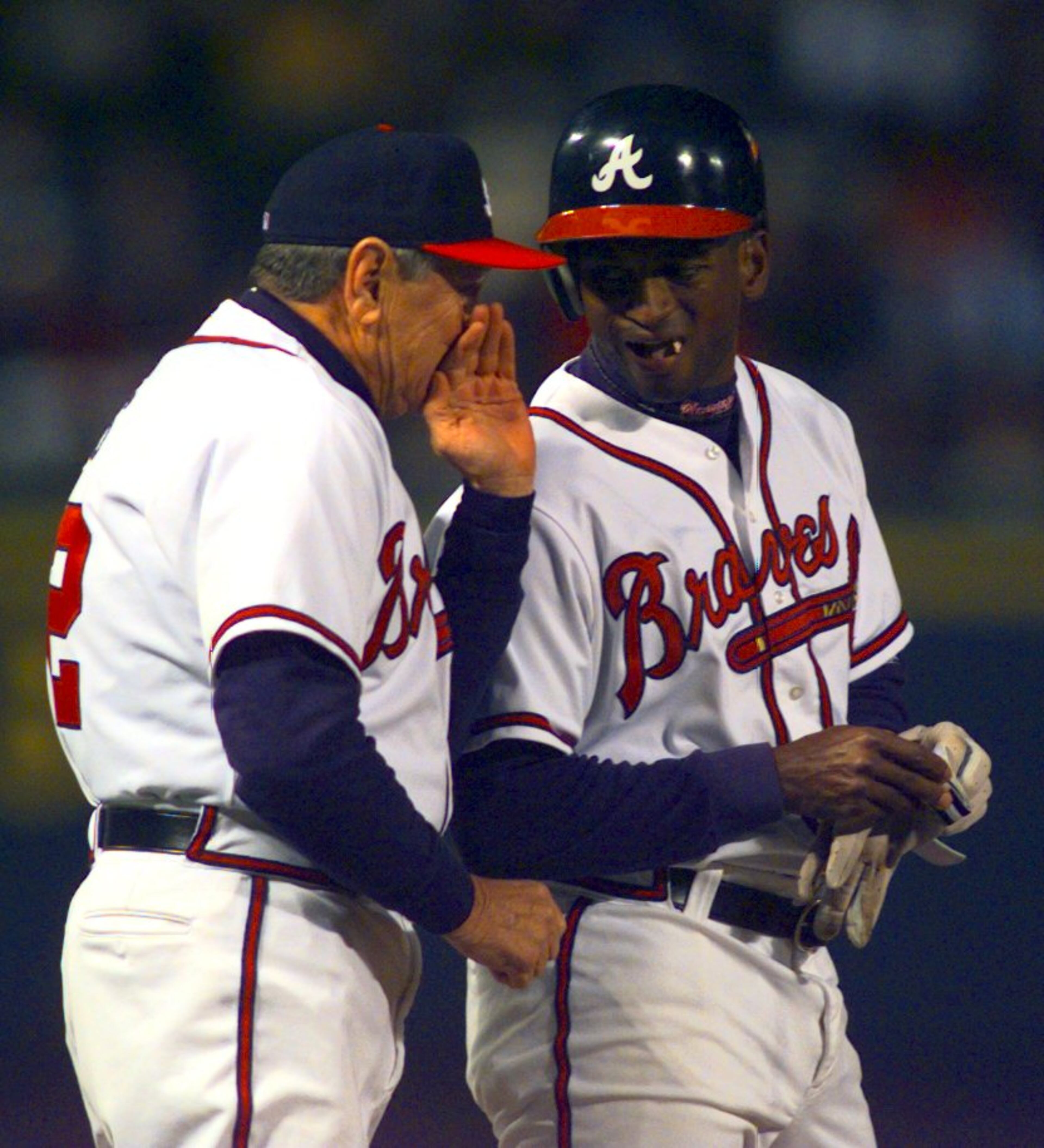 980404 ATLANTA, GA: The Braves' third base coach Bobby Dews (52) talks with Curtis Pride (19) at third base after he tripled in the first inning Saturday night, April 4, 1998 at Turner Field. (ANITTA C. CHARLSON/SPECIAL)