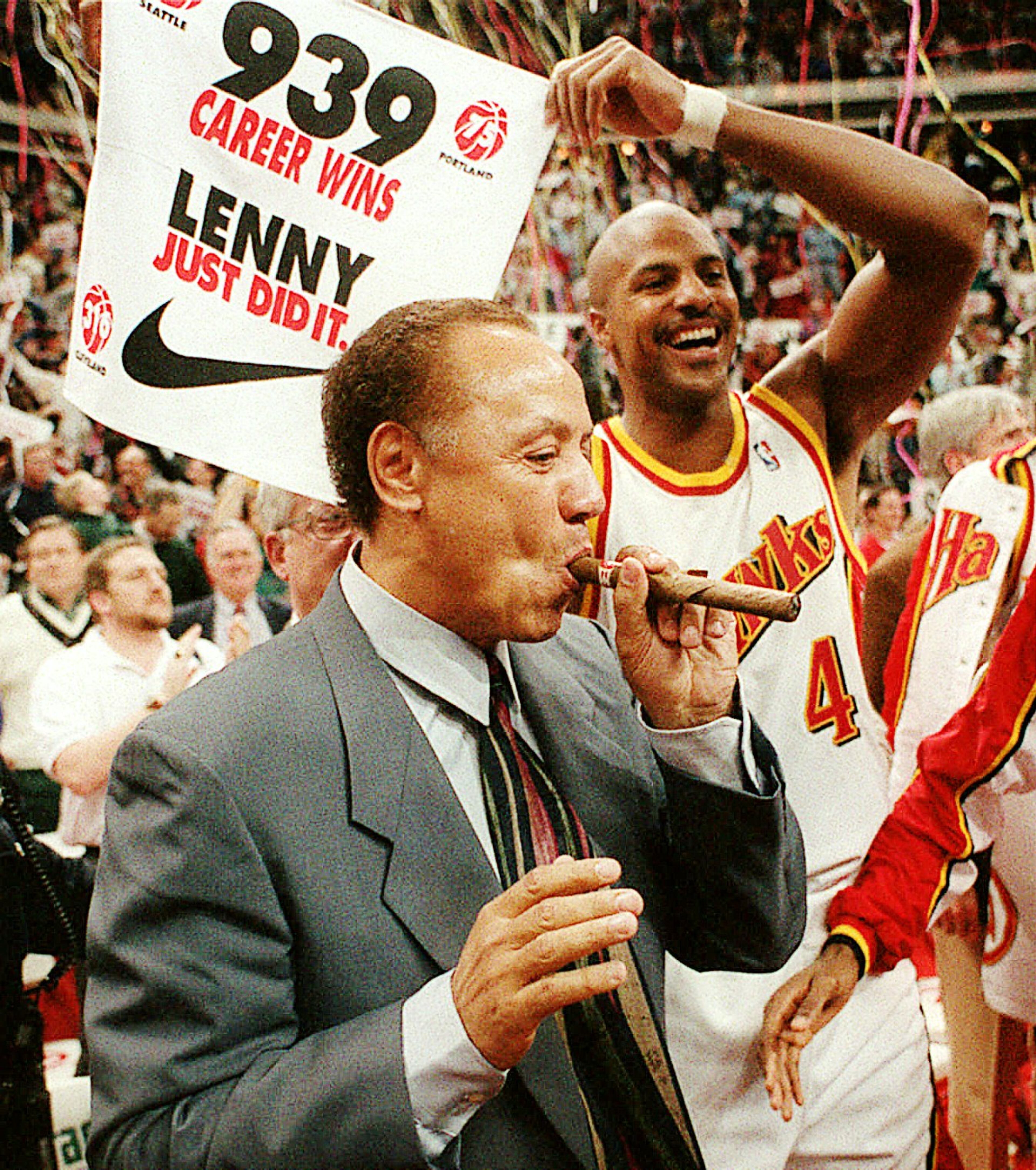 Atlanta Hawks coach Lenny Wilkens enjoys a celebratory cigar after his record-breaking 939th victory in 1995. AJC file photo