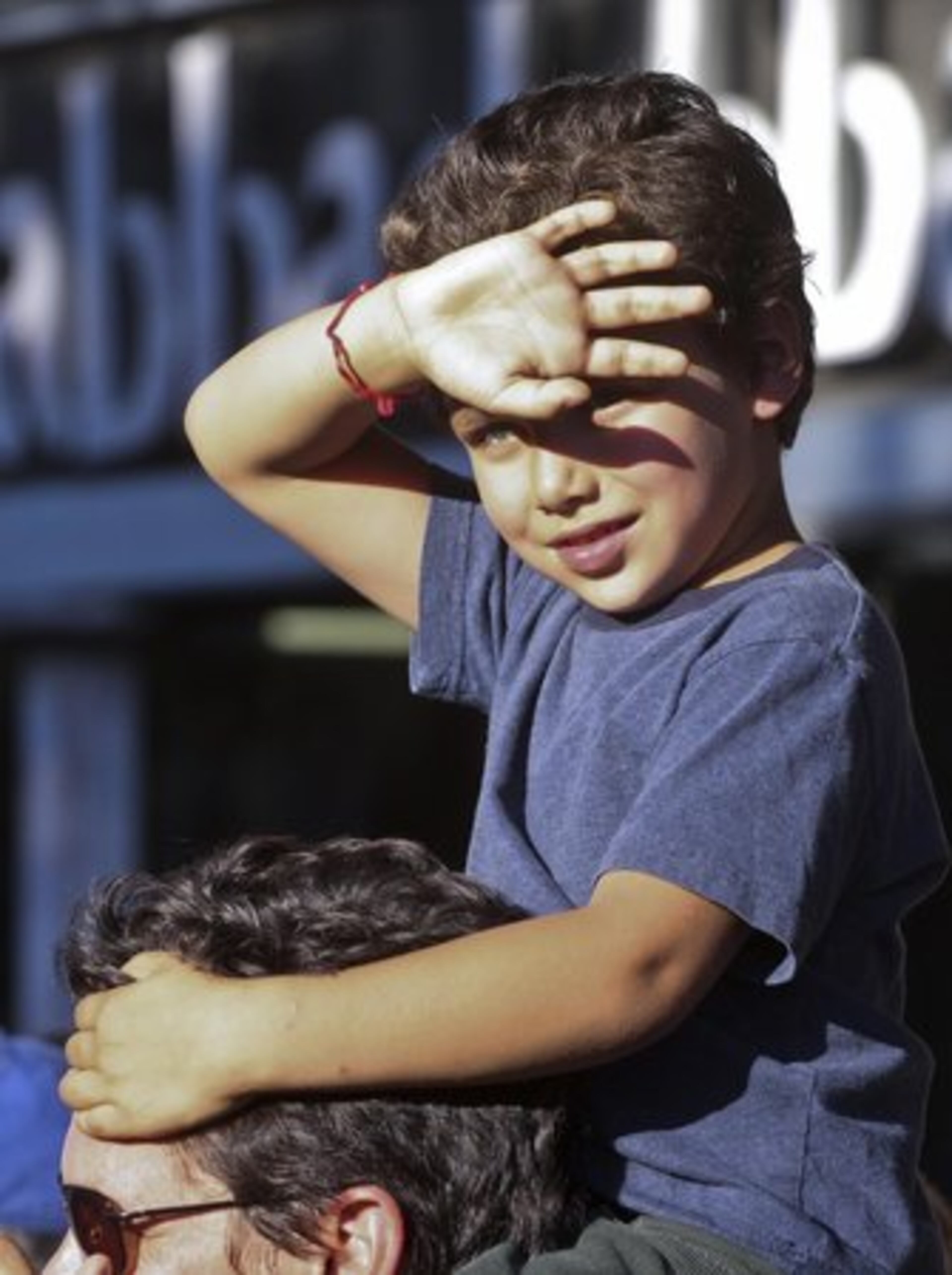 Emilio Gonzalez, 5 sits on his father's shoulders Saul Gonzalez to get a better view of the unique costumes at the 10th Annual Little Five Points Halloween Parade.