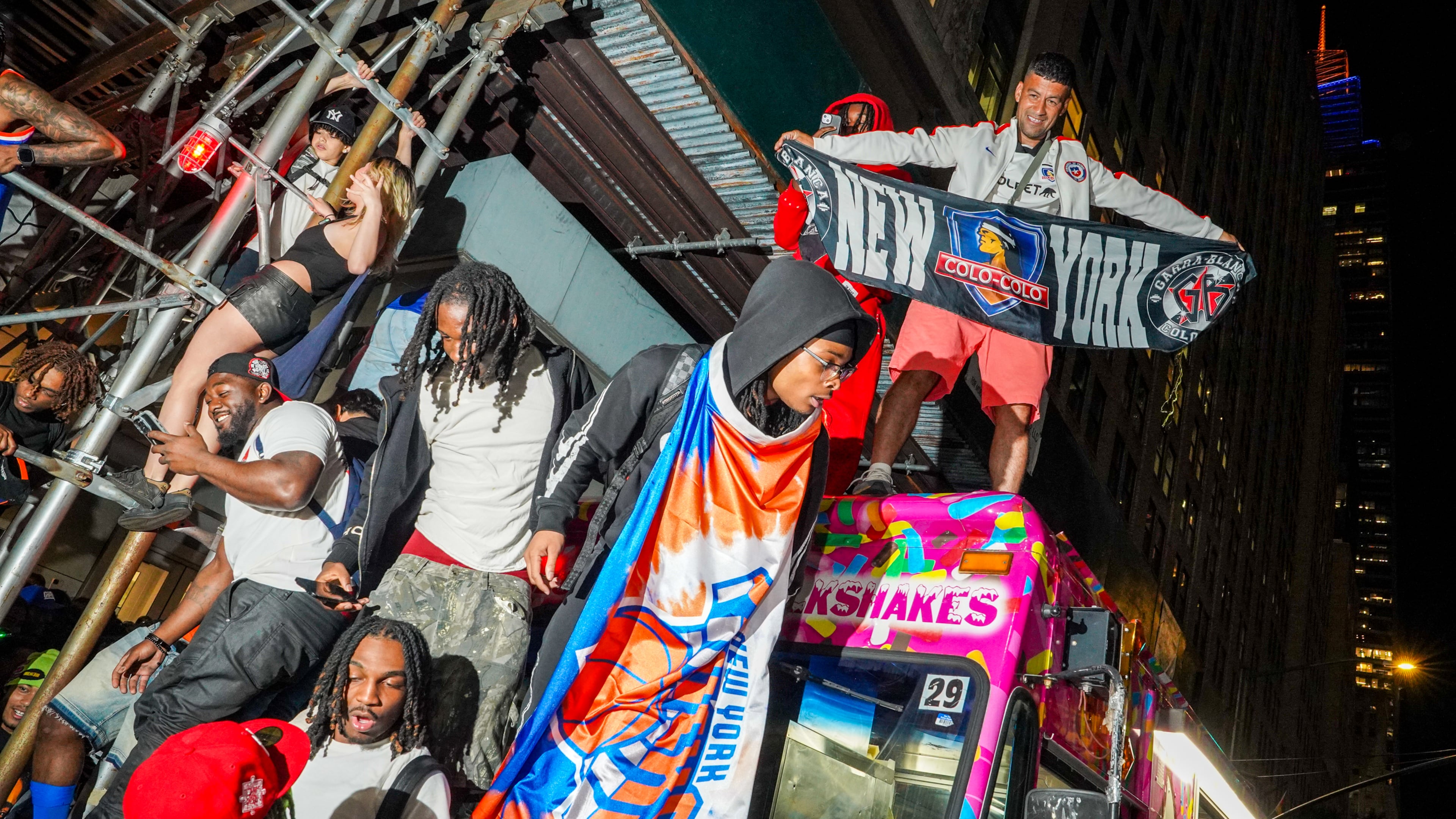 New York Knicks fans celebrate on the street outside of a watch party in Bryant Park for Game 3 of the NBA Finals basketball series between the Knicks and the San Antonio Spurs, Monday, June 8, 2026, in New York. (AP Photo/Ryan Murphy)