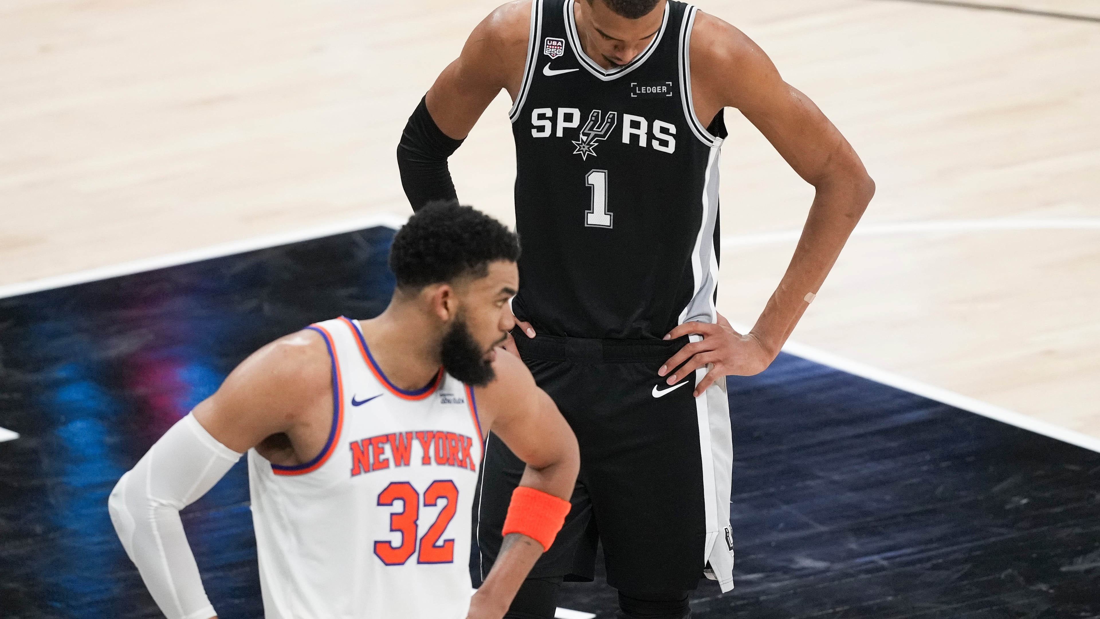 San Antonio Spurs forward Victor Wembanyama (1) looks down as New York Knicks center Karl-Anthony Towns (32) looks towards his bench during the second half of Game 1 of the NBA Finals basketball series, Wednesday, June 3, 2026, in San Antonio. (AP Photo/Eric Gay)