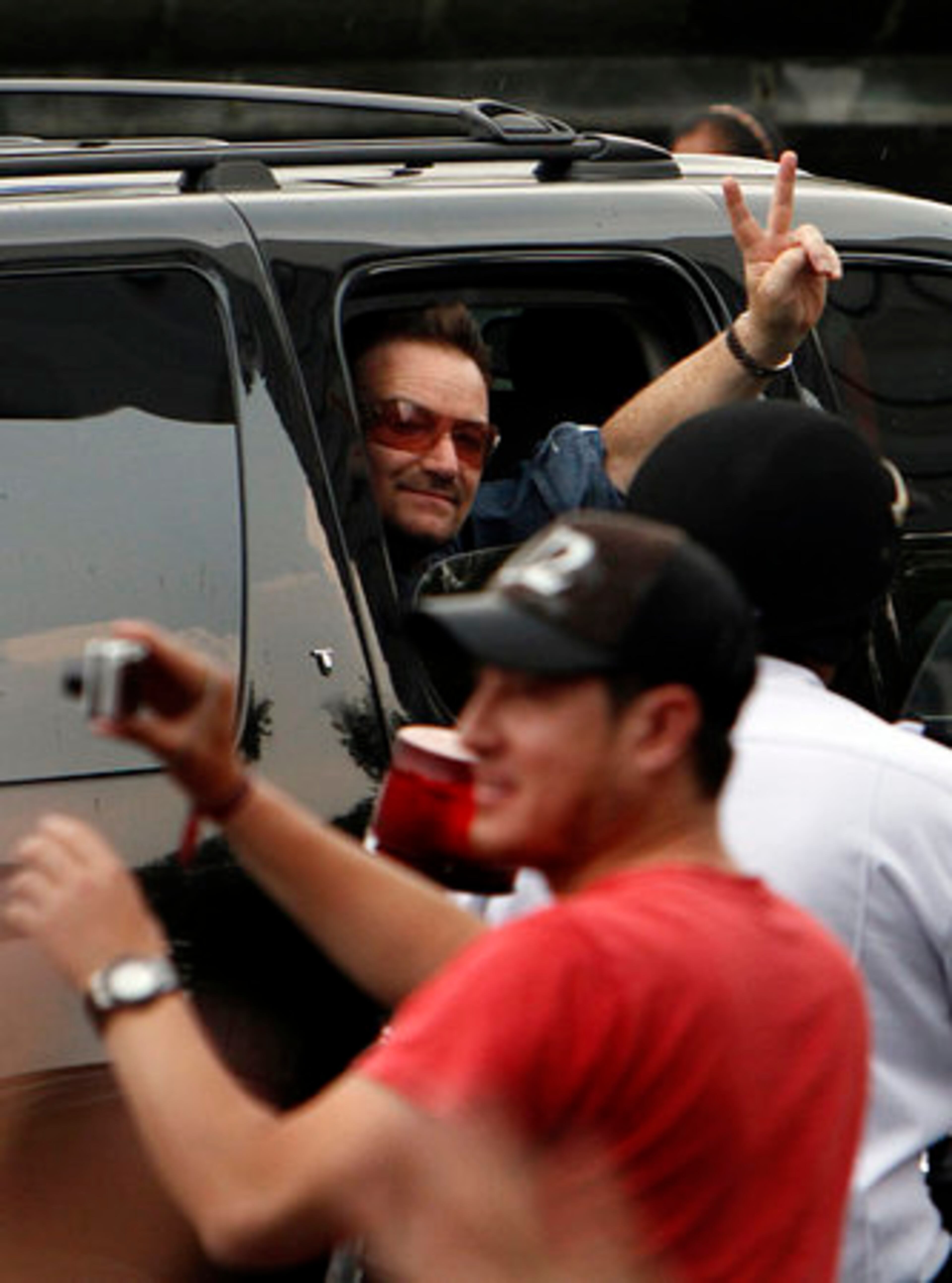 Bono waves to fans before the concert.