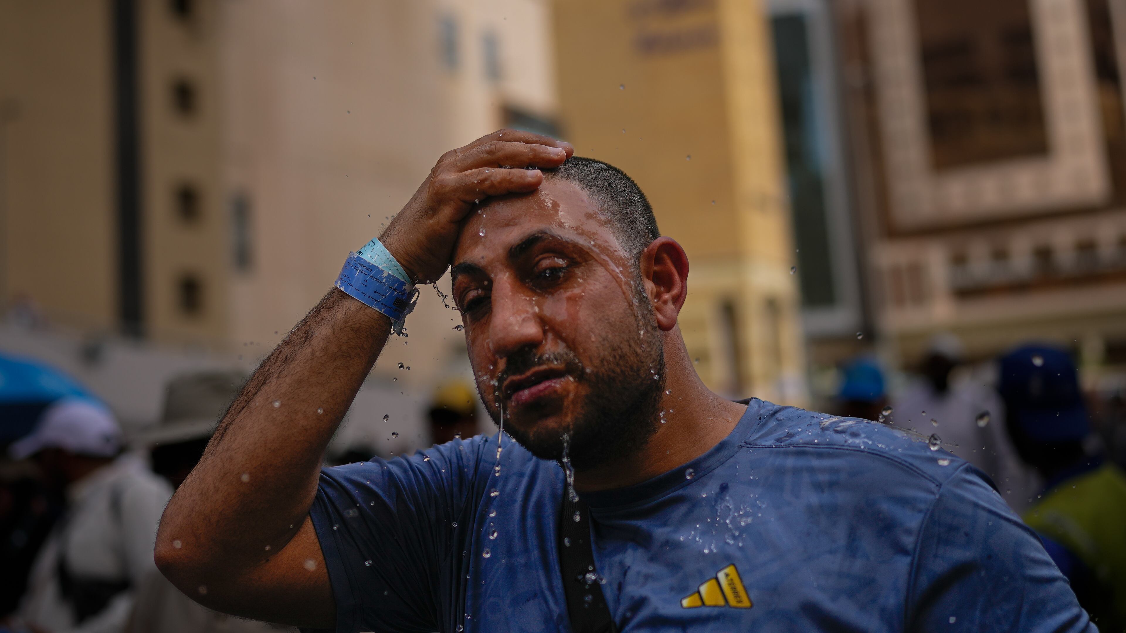 A Muslim pilgrim splashes water over his head too cool down outside the Grand Mosque during the annual hajj pilgrimage at the holy city of Mecca, Saudi Arabia, Sunday, May 24, 2026. (AP Photo/Altaf Qadri)