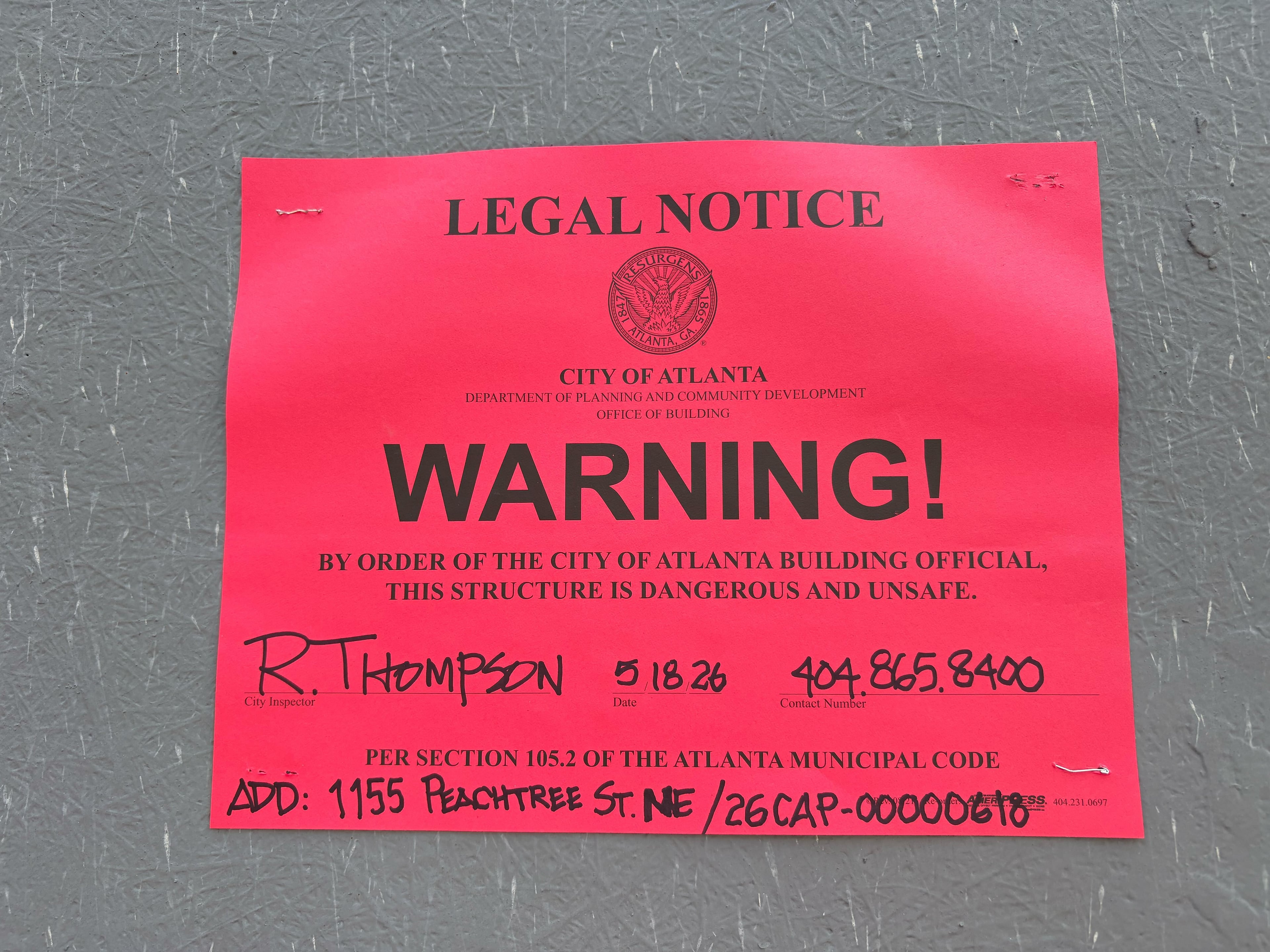 A legal notice from the city of Atlanta dated Monday, May 18, 2026, and posted on the work site of the Campanile building in Midtown Atlanta. (Zachary Hansen/AJC)