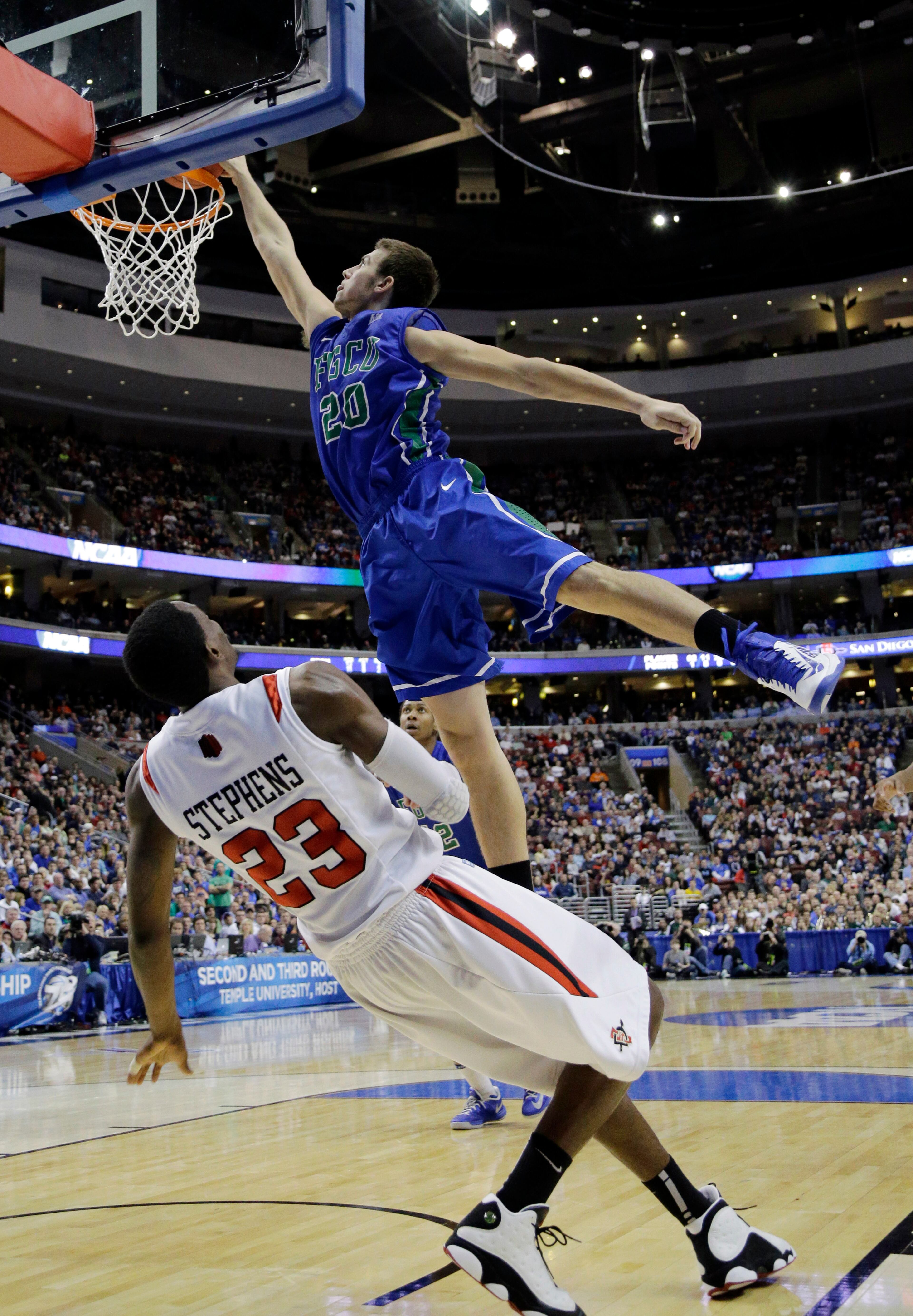 Florida Gulf Coast's Chase Fieler, top, dunks over San Diego State's Deshawn Stephens during the first half of a third-round game of the NCAA college basketball tournament, Sunday, March 24, 2013, in Philadelphia. (AP Photo/Matt Slocum)