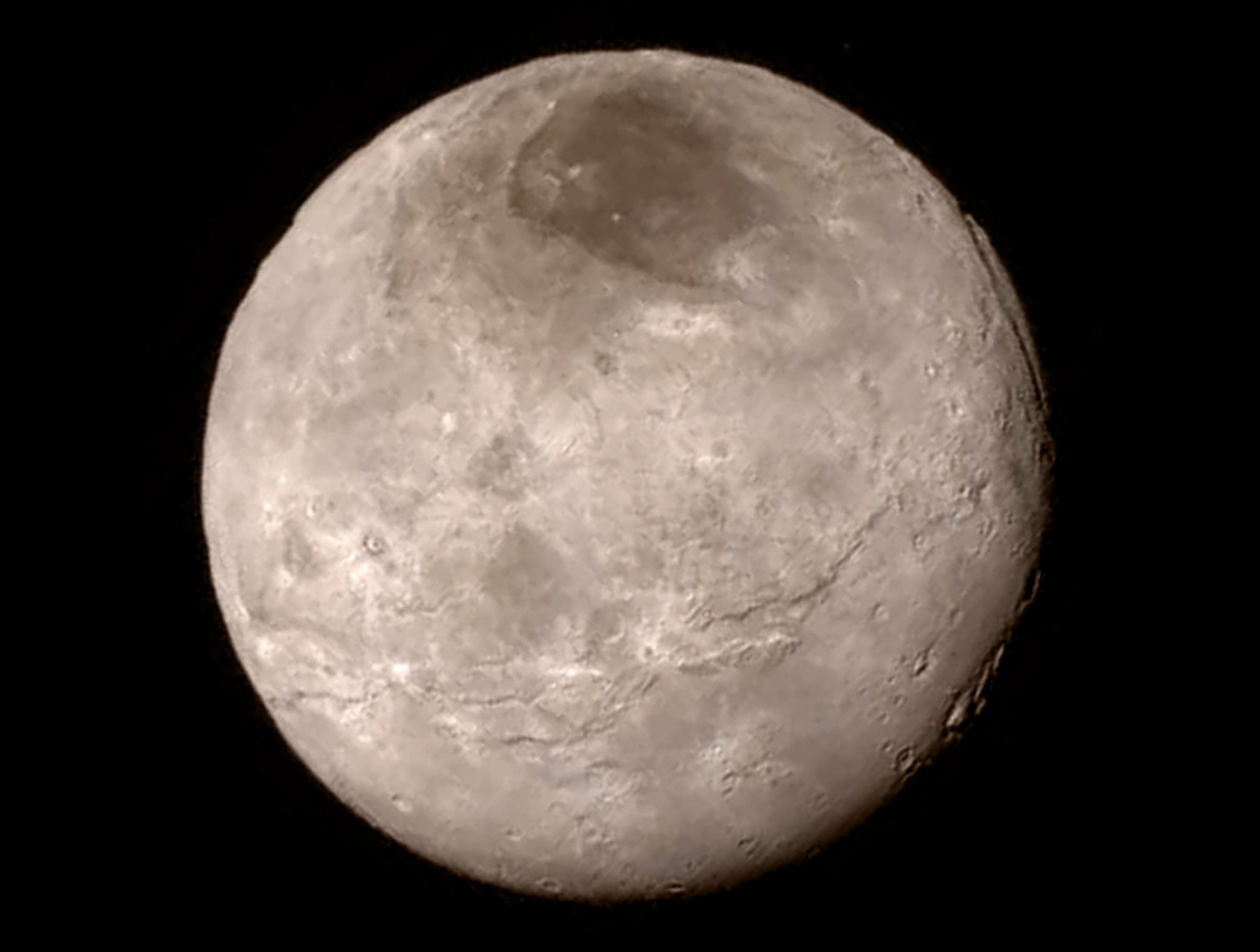 A handout photo taken by NASA's New Horizons spacecraft of Charon, Pluto's largest moon, and its dark patch, informally called Mordor. A day after its successful flyby, the New Horizons spacecraft, which spent nine years traveling three billion miles to study the dwarf planet, sent back the first close-up photographs of Pluto and Charon. (NASA via The New York Times) '