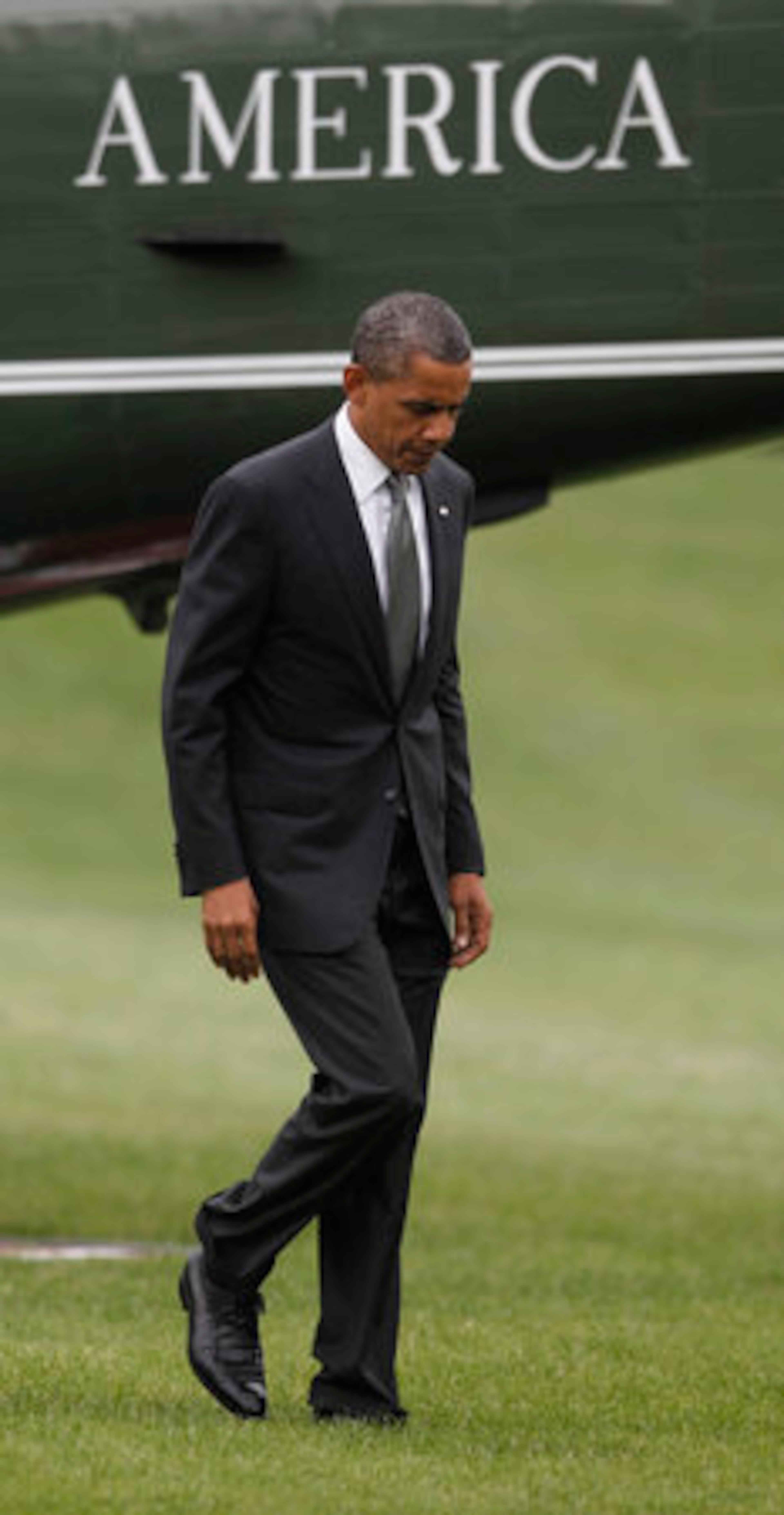 President Barack Obama walks across the South Lawn of the White House in Washington following his arrival on Marine One helicopter, Friday, July 20, 2012. Obama cut short his campaign stop in Florida in the aftermath of the tragic mass shooting at a movie theater in Aurora, Colo.