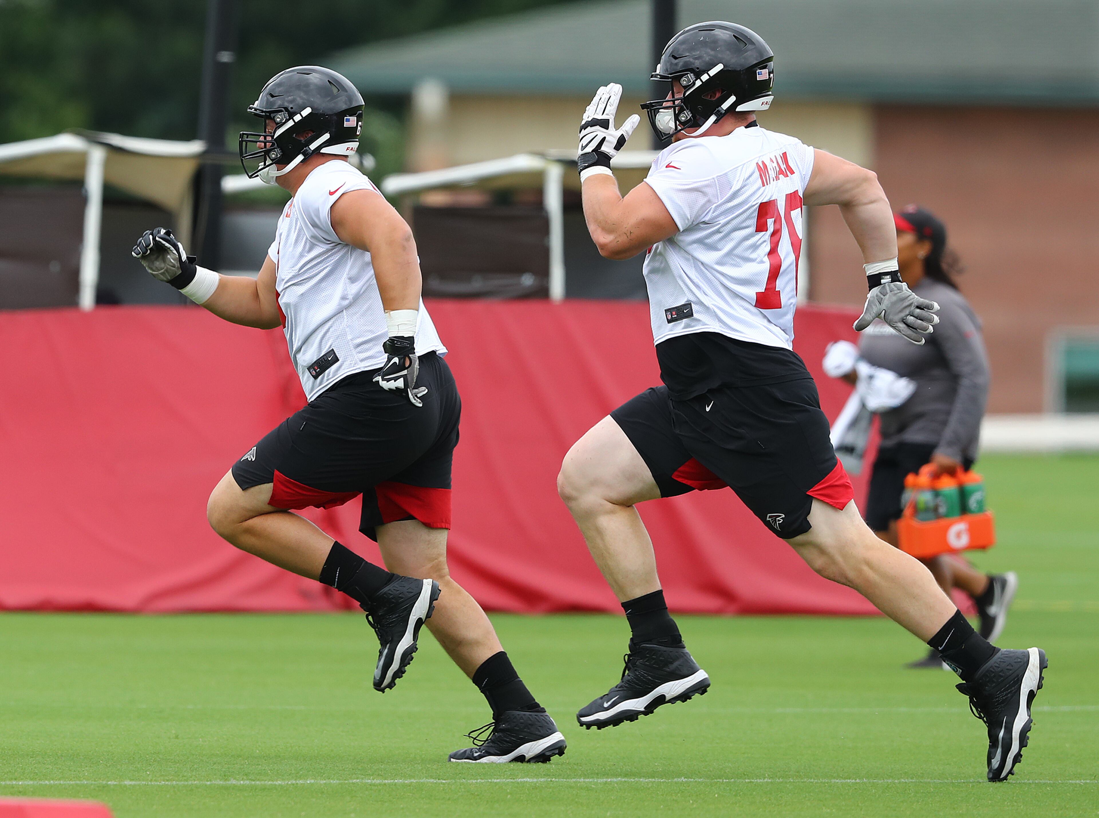 Rookie linemen on the move: Top draft pick Chris Lindstrom (left) and Kaleb McGary race across the field to the next drill. (Curtis Compton/ccompton@ajc.com).