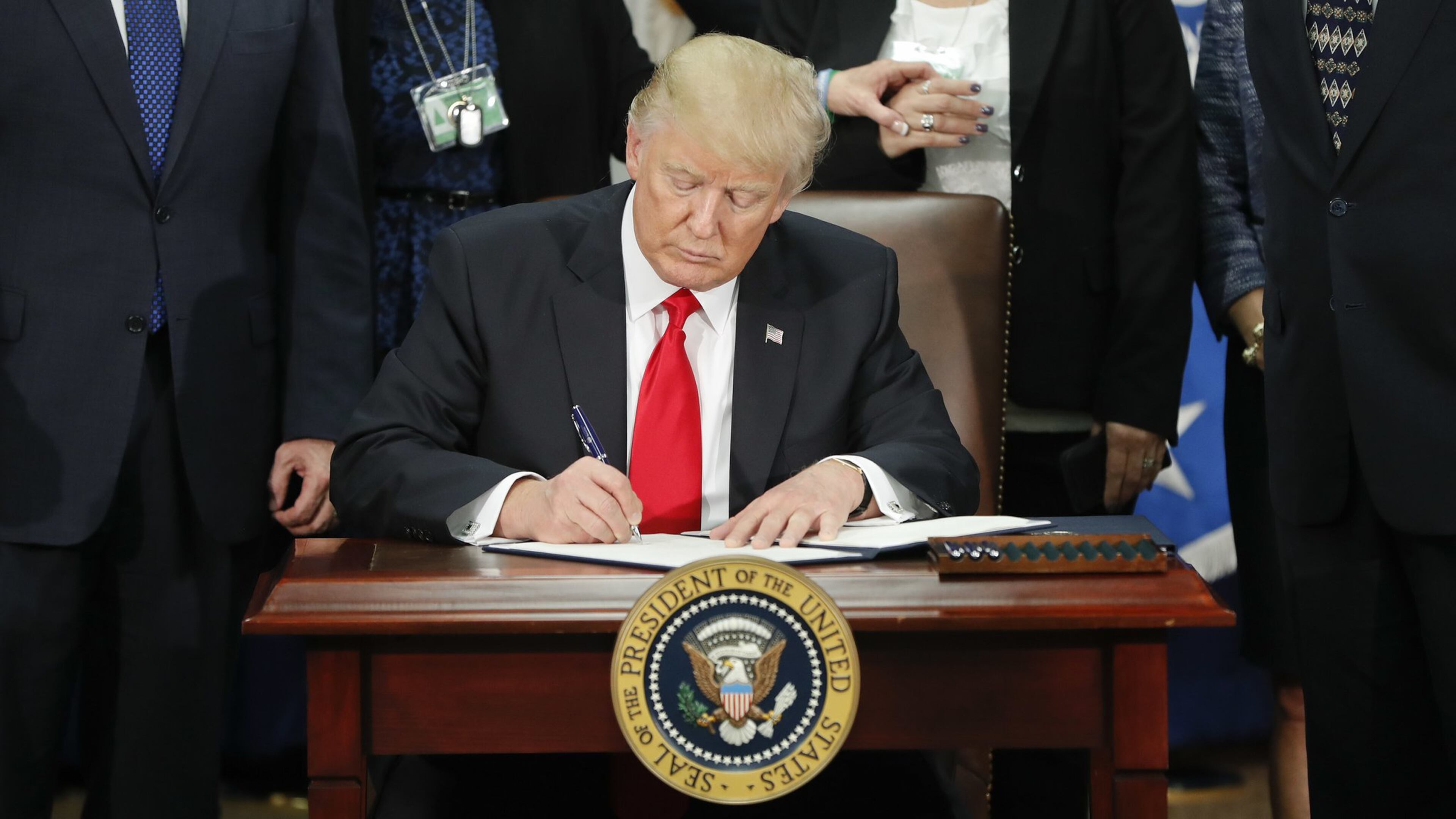 In this Jan. 25, 2017, photo President Donald Trump signs an executive order for border security and immigration enforcement improvements at the Department of Homeland Security in Washington. Two days later, he signed a separate executive order temporally blocking travelers from seven predominantly Muslim countries and halting the resettlement of refugees in the U.S. (AP Photo/Pablo Martinez Monsivais)