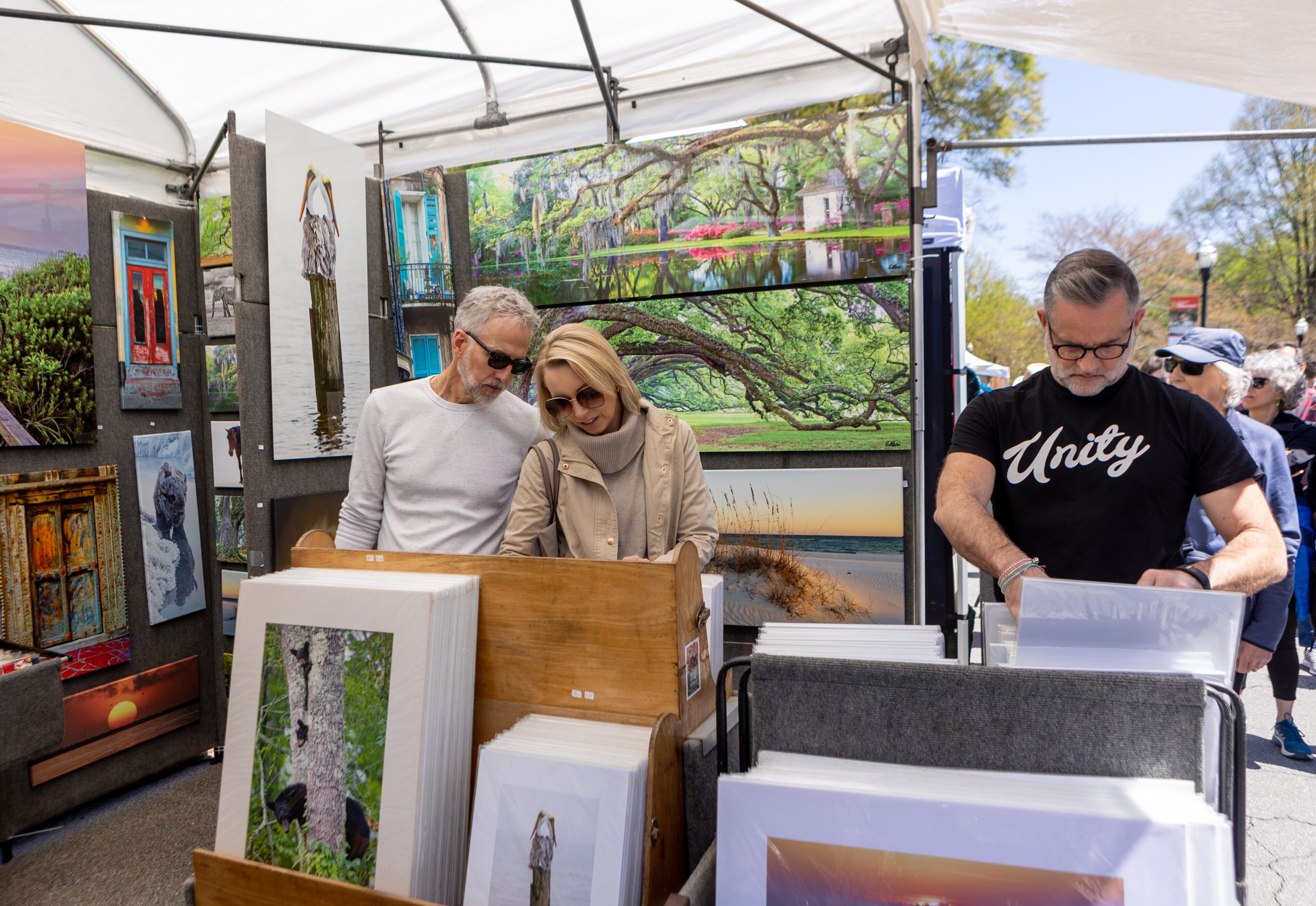 Rob and Julia Better, left, of Milton, look at Brian K Miller Photography prints on Sunday, April 10, 2022 at the 86th annual Atlanta Dogwood Festival in Piedmont Park. This year’s three-day festival had art of all shapes and sizes, jewelry, fare food and a kids village with arts and crafts, games and rides. (Jenni Girtman for The Atlanta Journal-Constitution)