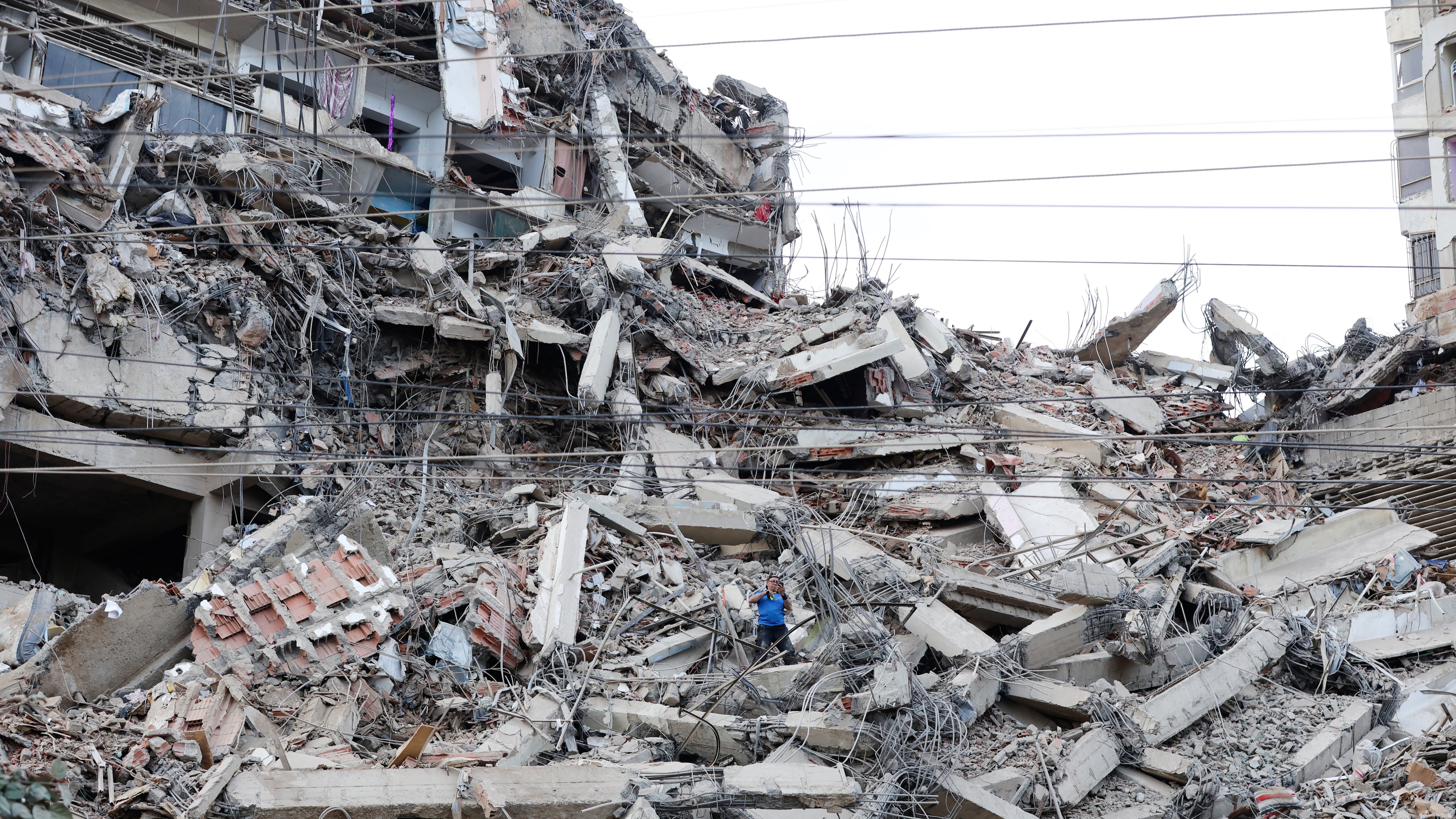 A man walks among the rubble of a building that collapsed in earthquakes the previous day in La Guaira, Venezuela, Thursday, June 25, 2026. (AP Photo/Pedro Mattey)
