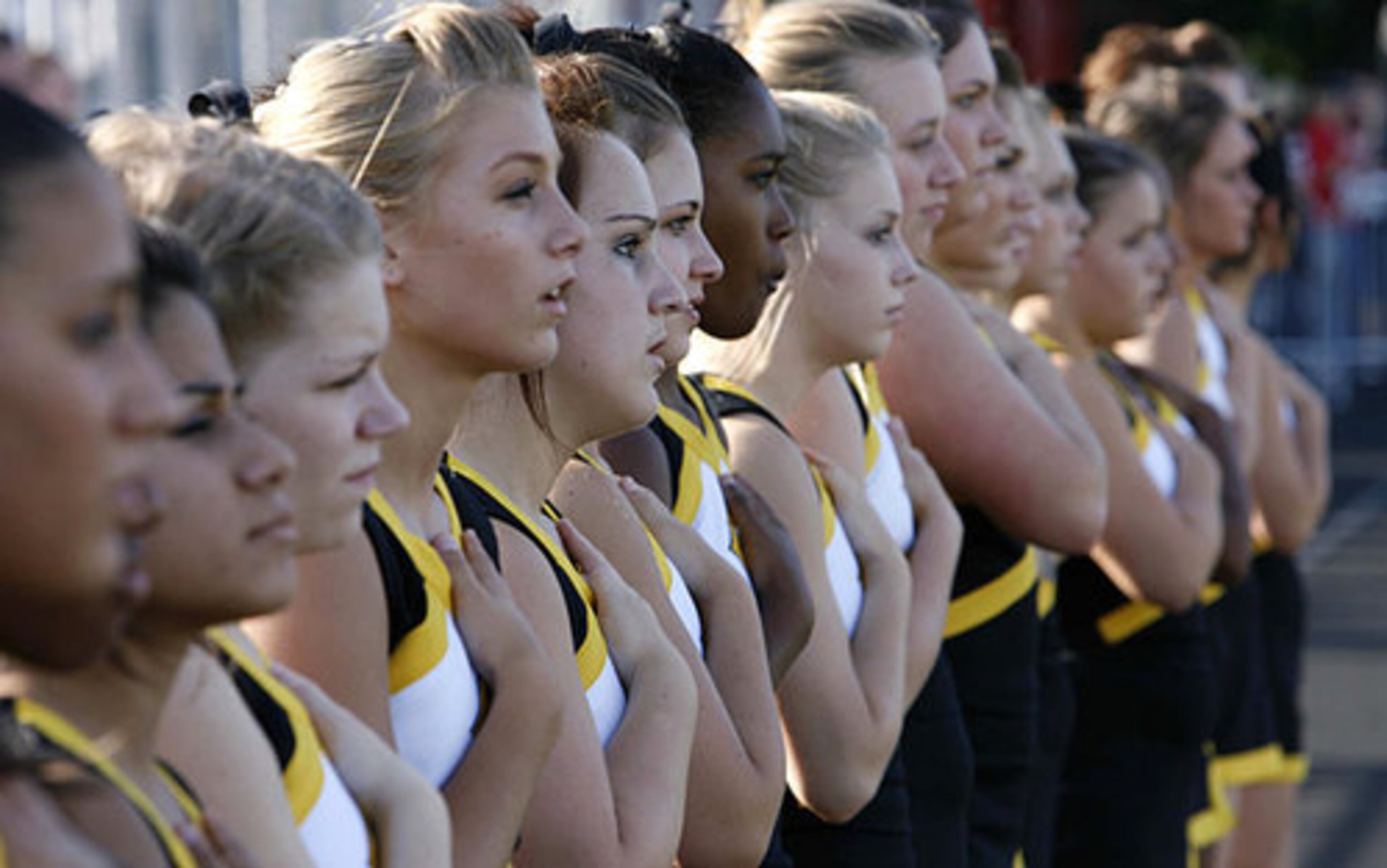 Central Gwinnett's cheerleaders observe the national anthem before the start of Friday night's game against Mainland.