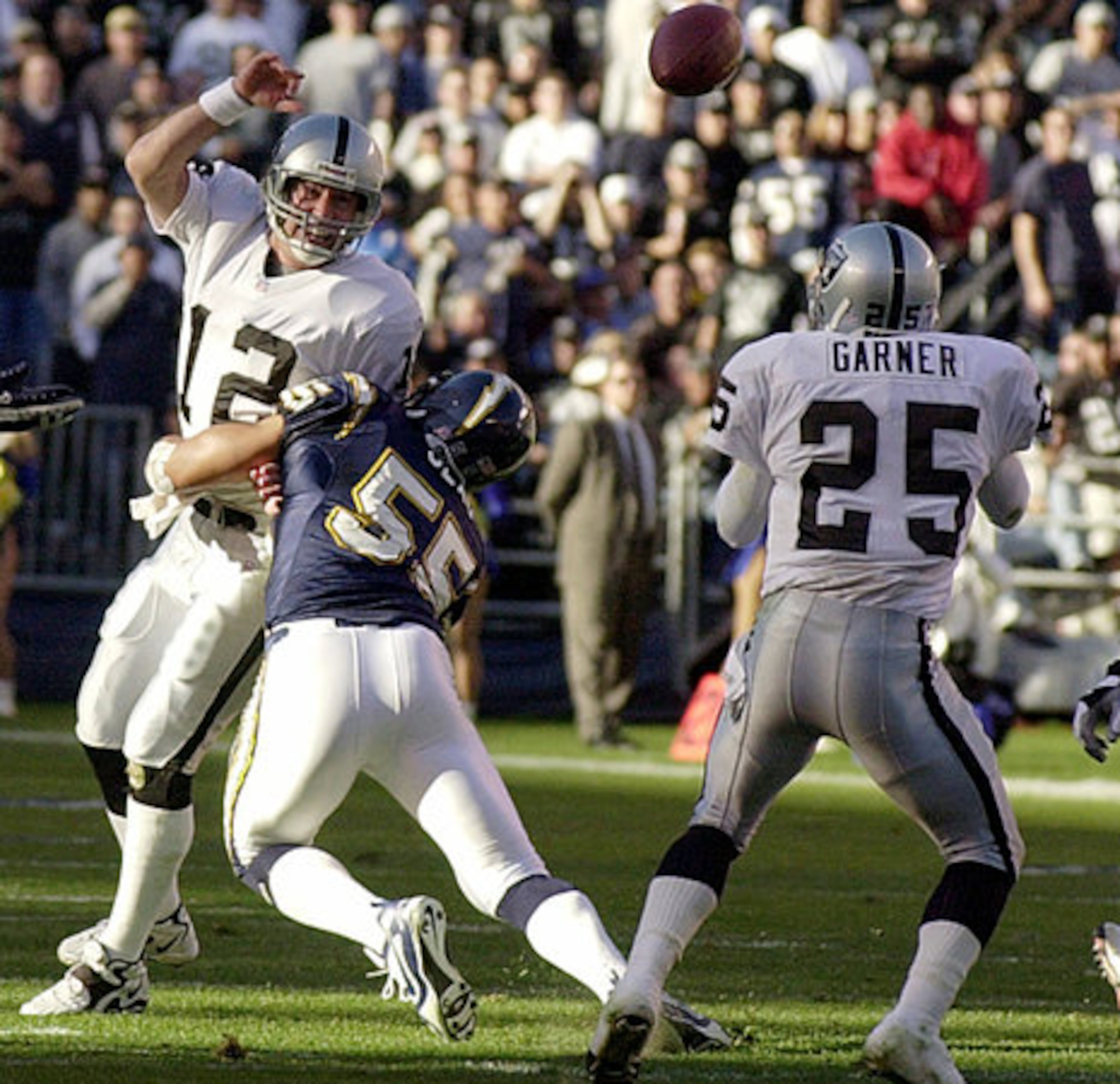 San Diego Chargers' Junior Seau (55) delivers a hit to Oakland Raider's running back Charlie Garner during a December 2001 game.
