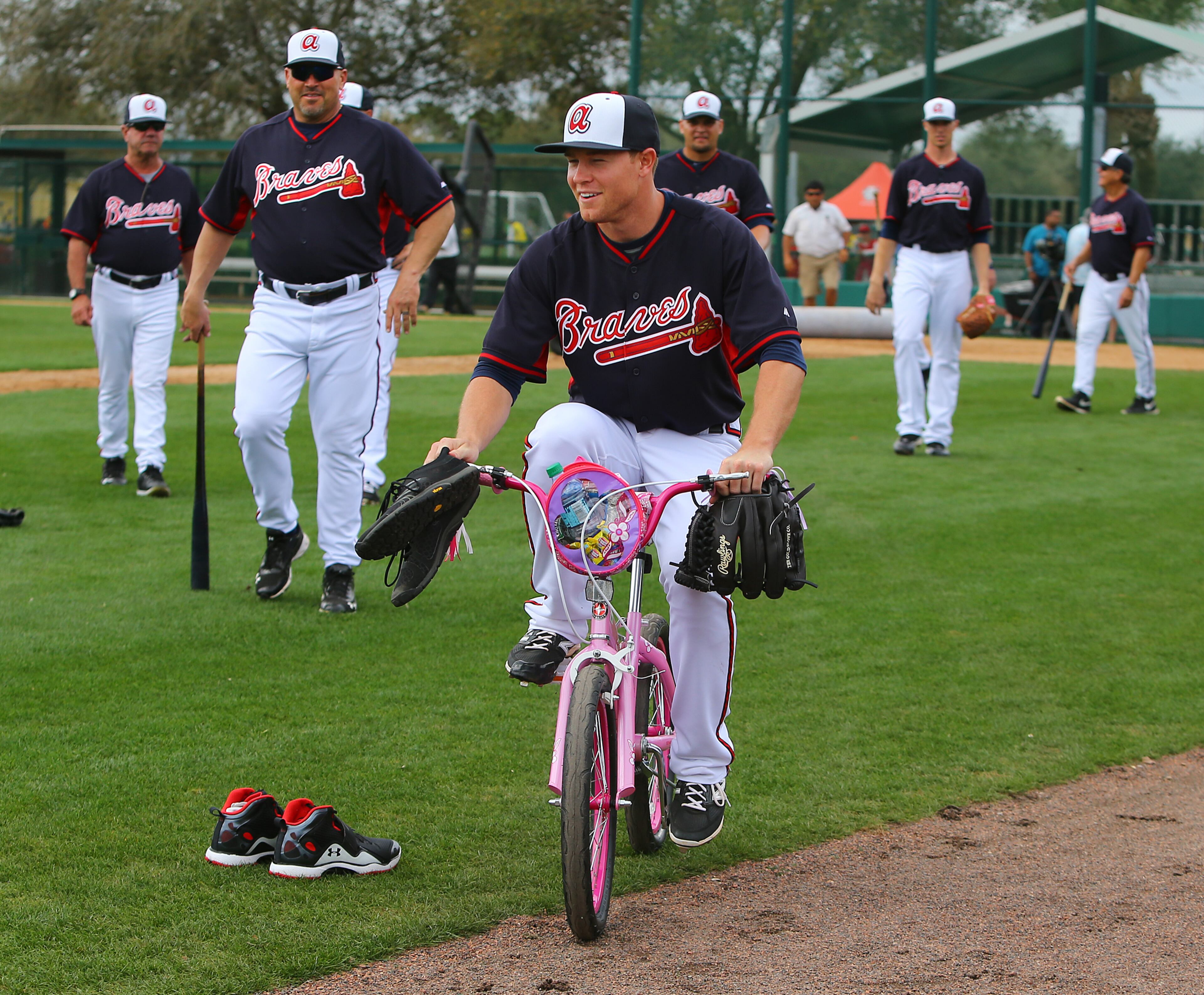 Braves manager Fredi Gonzalez (left) looks on amusingly while pitcher Shae Simmons pulls away on a pink bicycle that he was forced to ride during spring training on Friday, Feb. 21, 2014, in Lake Buena Vista, FL. Braves outfielder B.J. Upton apparently brought in the bike today as a gag and Simmons somehow won the honors. CURTIS COMPTON / CCOMPTON@AJC.COM