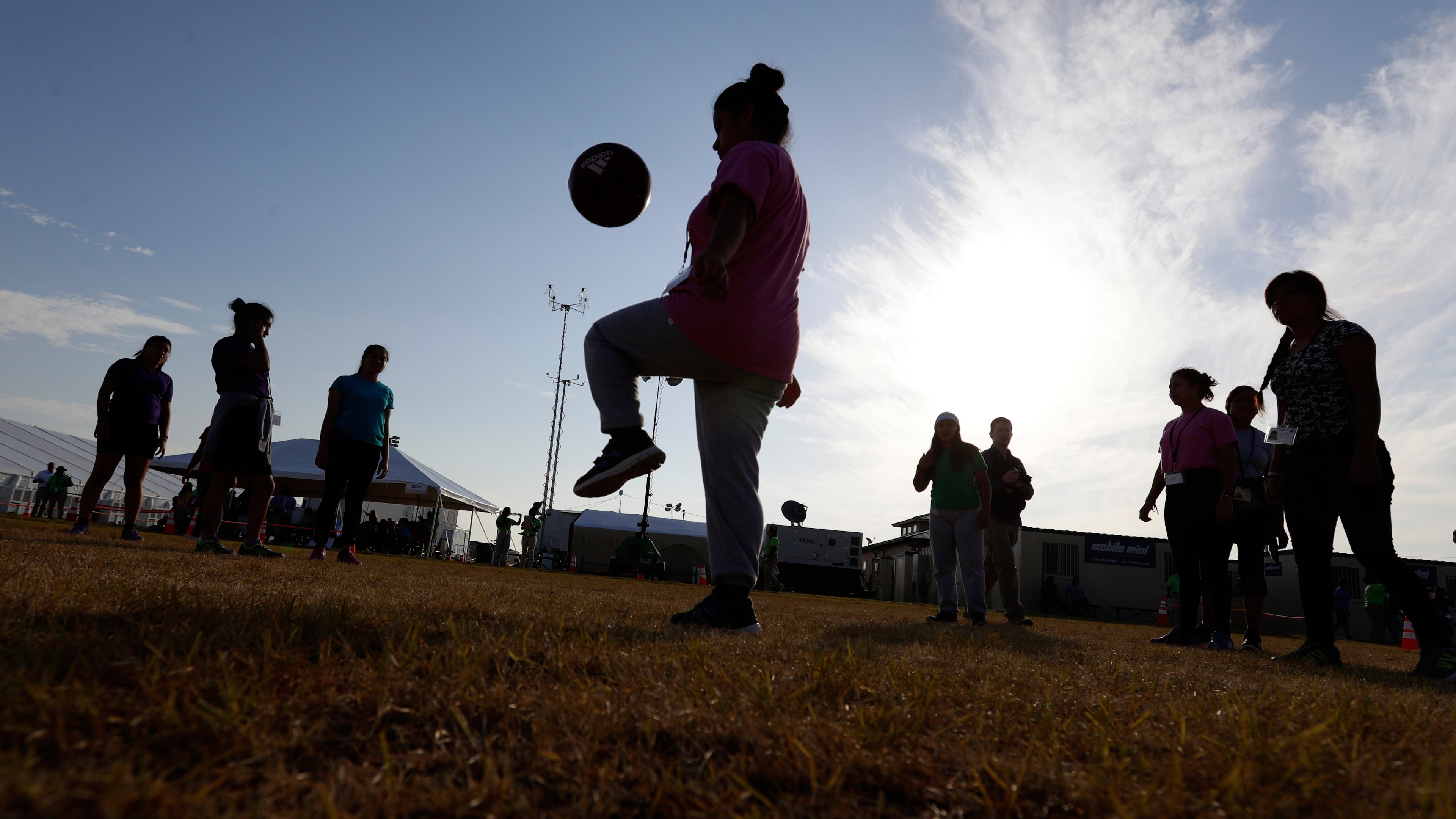 FILE - Immigrants play soccer at a new U.S. government holding center for migrant children, in Carrizo Springs, Texas, July 9, 2019. (AP Photo/Eric Gay, File)