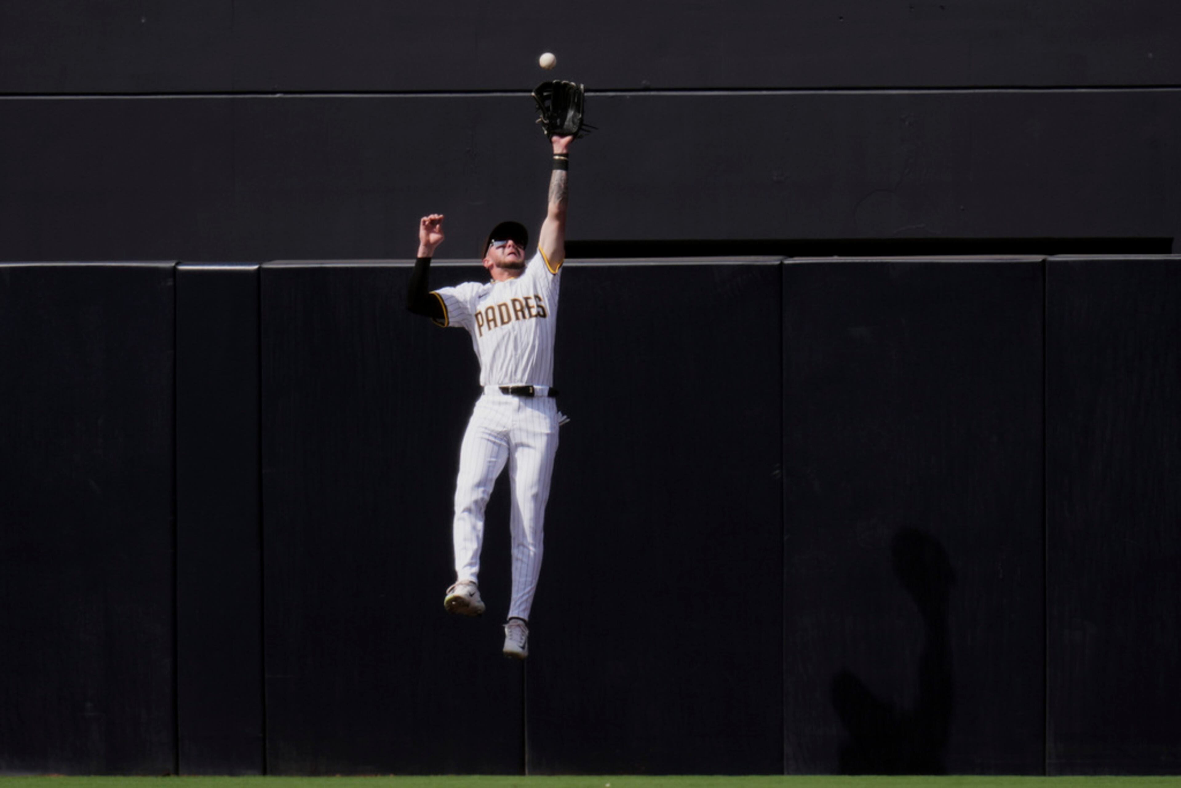San Diego Padres center fielder Jackson Merrill makes a catch at the wall for the out on Atlanta Braves'Jarred Kelenic during the sixth inning of an opening-day baseball game Thursday, March 27, 2025, in San Diego. (AP Photo/Gregory Bull)