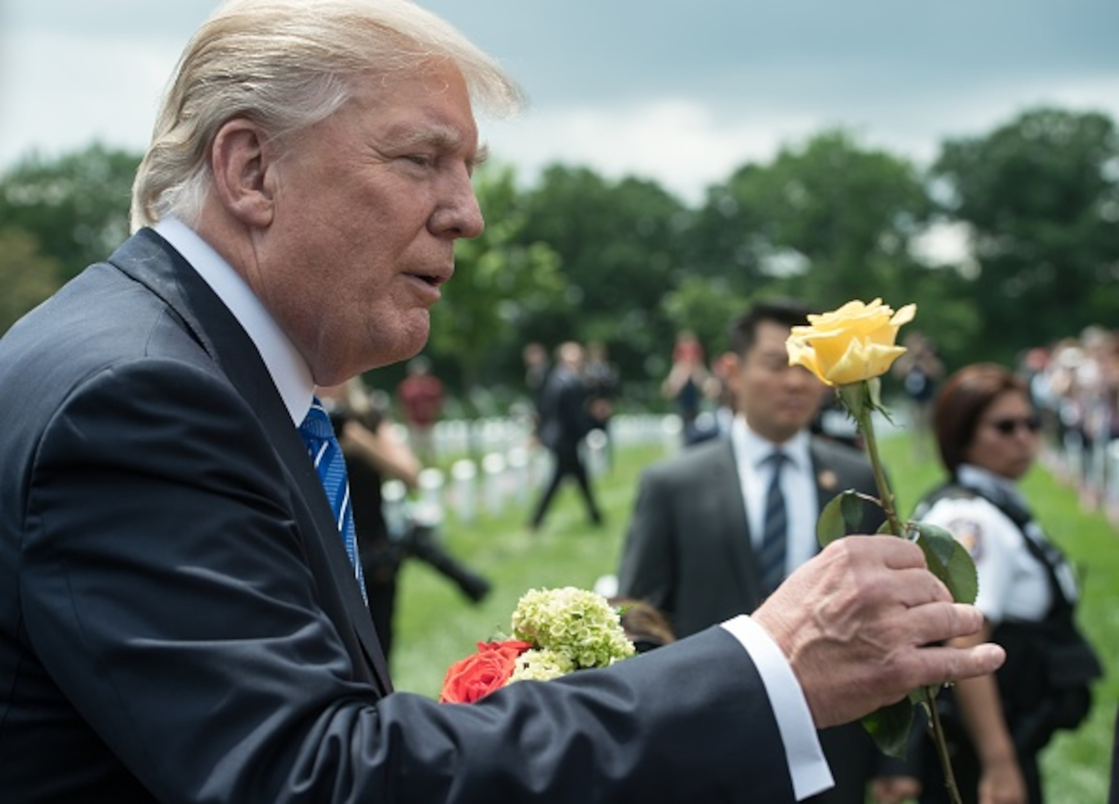 US President Donald Trump receives a flower from a woman as he visits Section 60 at Arlington National Cemetery to mark Memorial Day in Arlington, Virginia, on May 29, 2017 / AFP PHOTO / NICHOLAS KAMM (Photo credit should read NICHOLAS KAMM/AFP/Getty Images)
