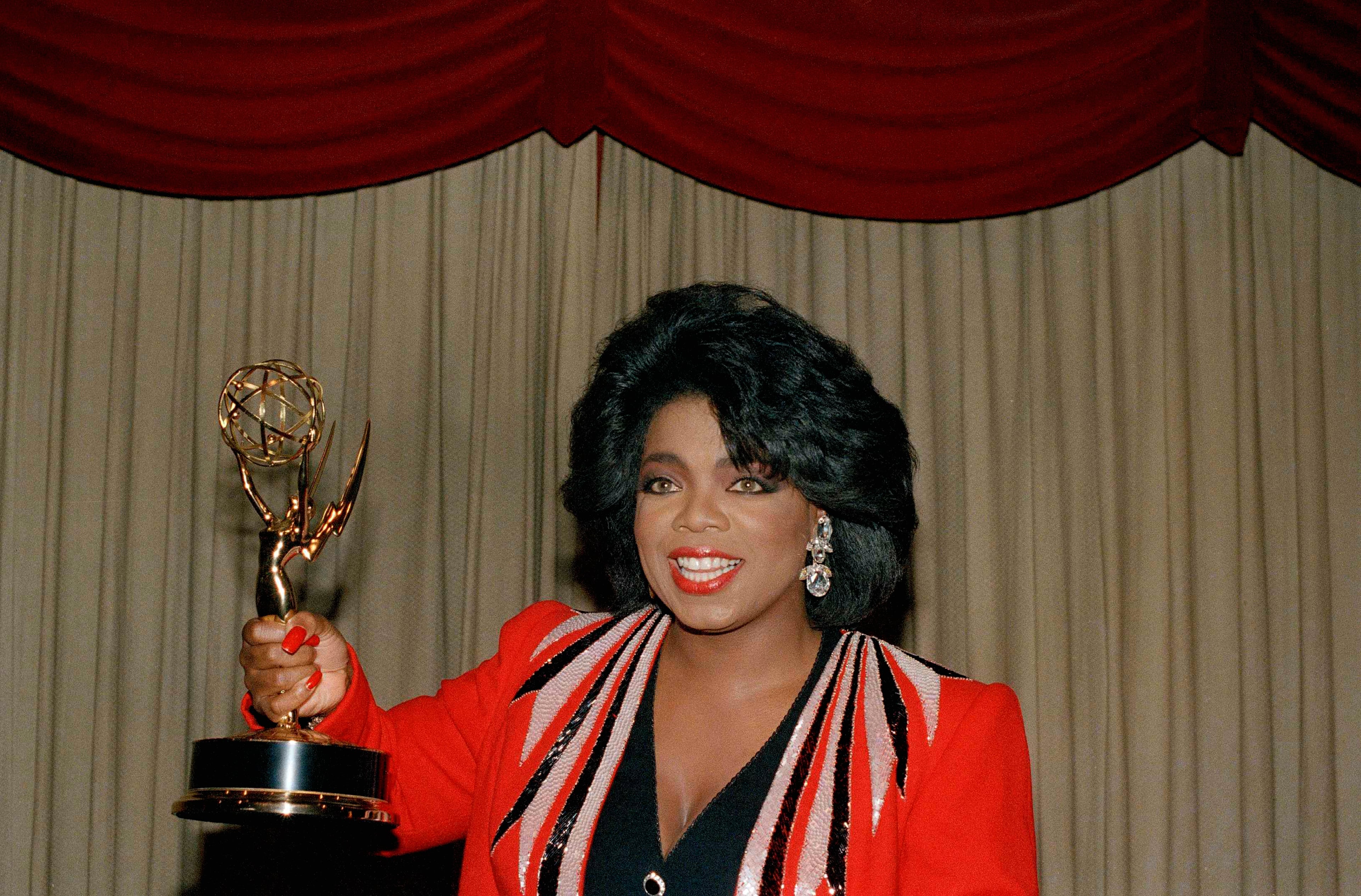 Talk show host Oprah Winfrey holds the trophy she was presented at the 14th Annual Daytime Emmy Awards ceremonies in New York, July 11, 1987. Her program, "The Oprah Winfrey Show," was named the Outstanding Talk/Service Show and she was named Outstanding Talk/Service Show Host. (AP Photo/Marty Lederhandler)