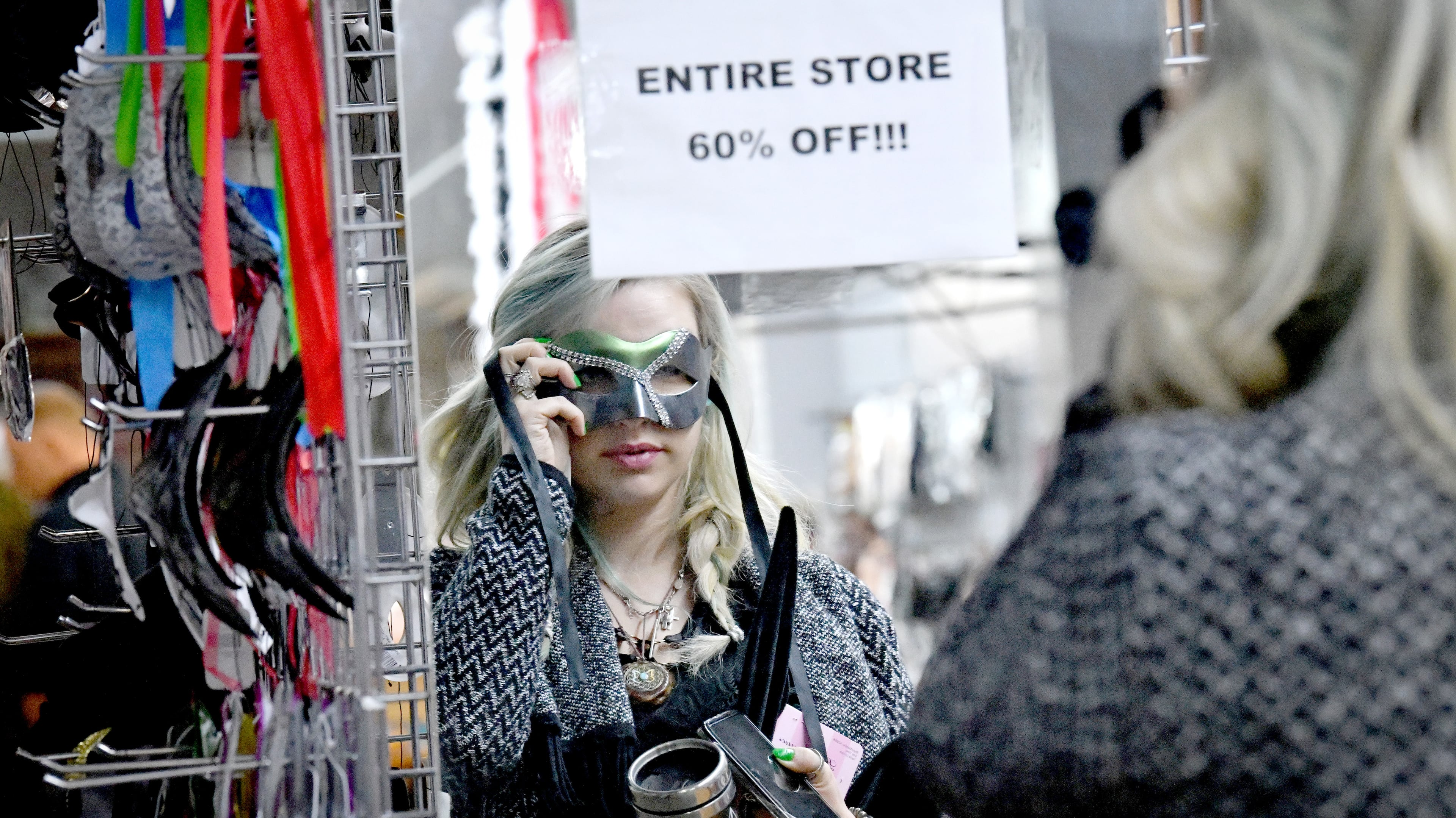 Lauren Donnelly tries on a costume eye mask during store closing sale at Eddie's Trick Shop in Marietta Square, Tuesday, February 6, 2024, in Marietta. Eddie’s Trick Shop, which sells and rents costumes and accessories and magic tricks, has been a Marietta staple since the mid-1970s. They announced on Feb. 2 they are closing down later this month. Currently, they are selling everything 60% off and a good portion of the store has already bene emptied. (Hyosub Shin / Hyosub.Shin@ajc.com)