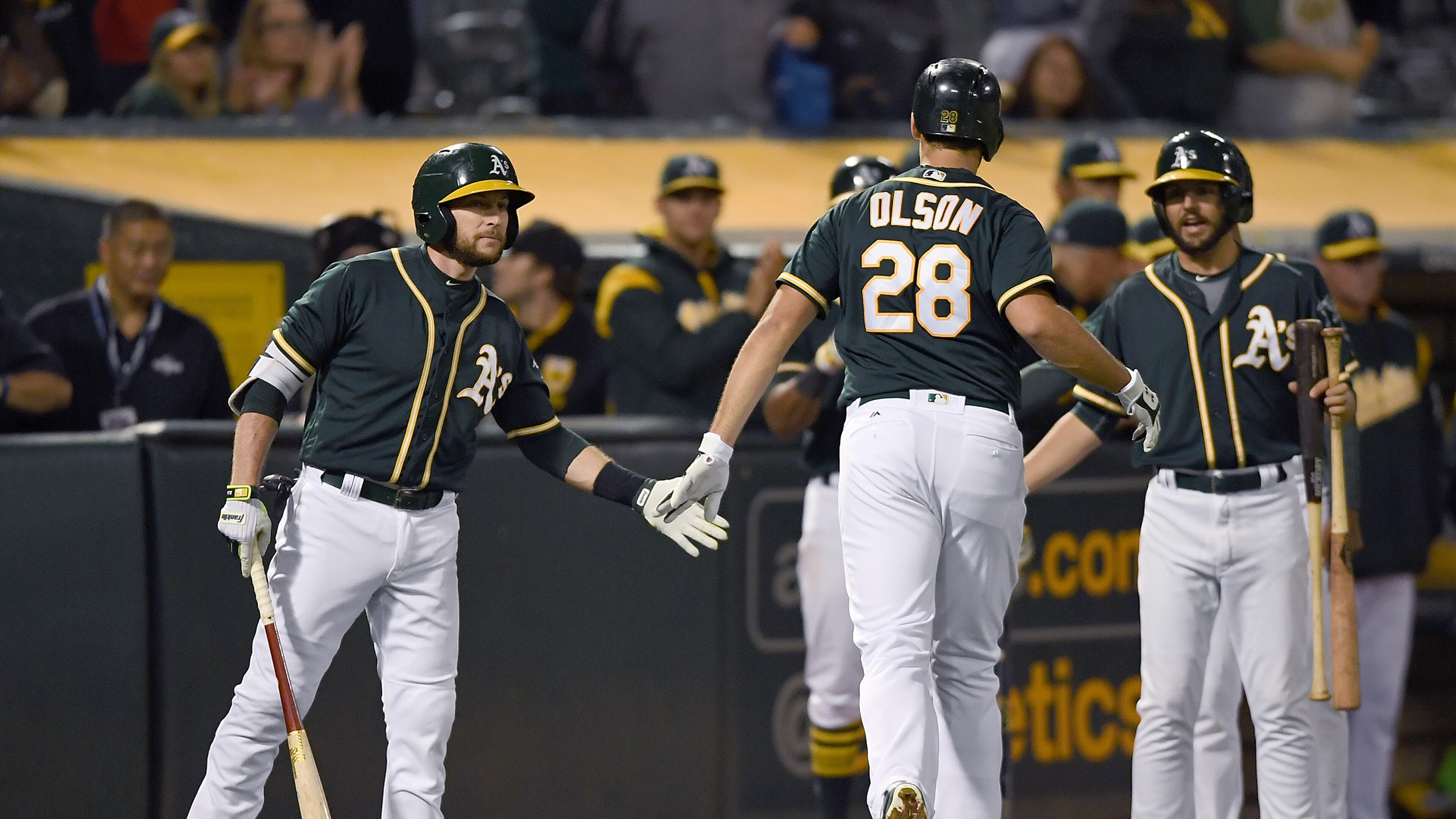 OAKLAND, CA - JUNE 30: Matt Olson #28 of the Oakland Athletics is congratulated by Jed Lowrie #8 after Olson broke up a no-hitter with a solo home run against the Atlanta Braves in the bottom of the ninth inning at Oakland Alameda Coliseum on June 30, 2017 in Oakland, California. The Braves won the game 3-1. (Photo by Thearon W. Henderson/Getty Images)