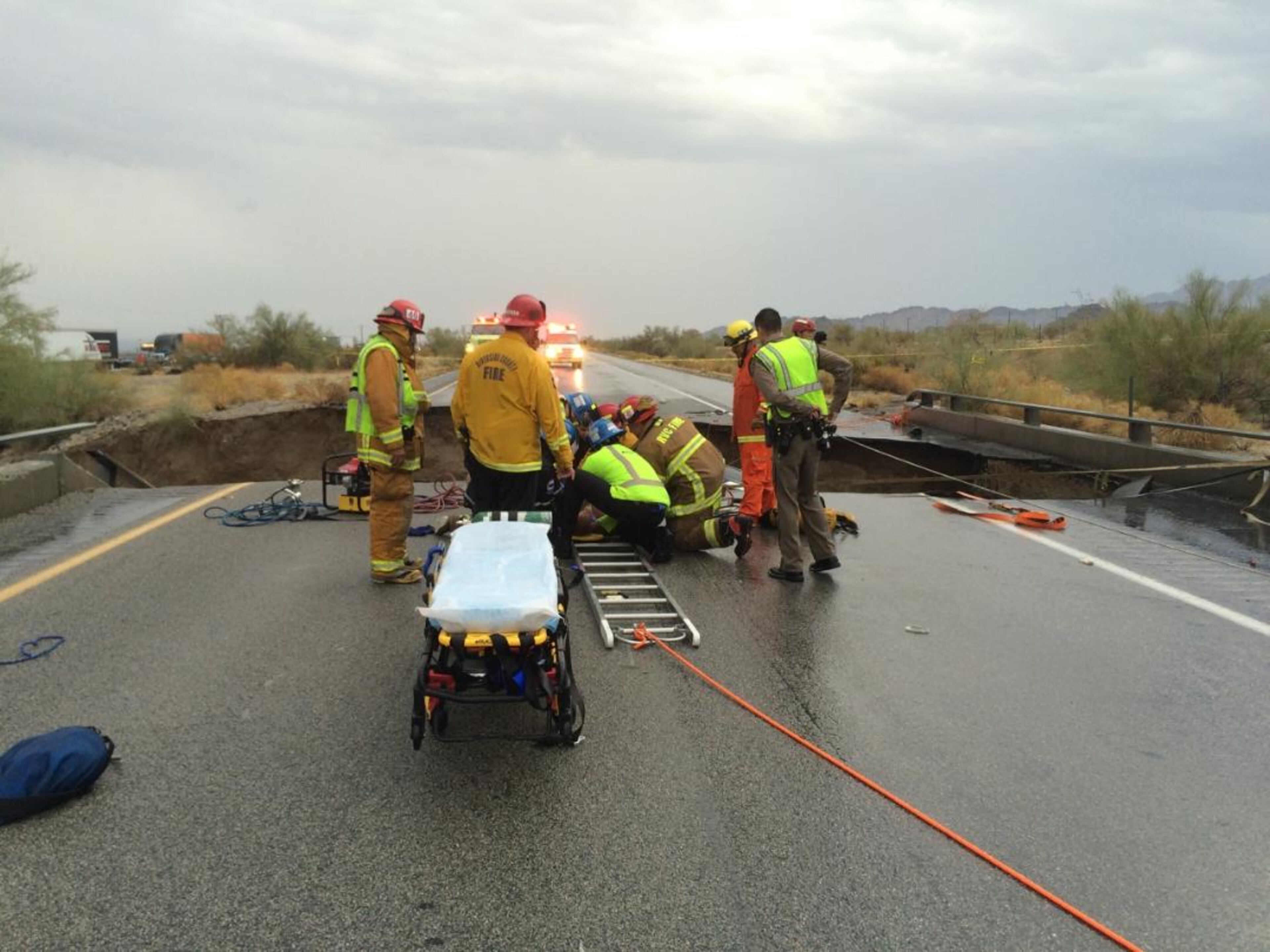 In this photo provided by the CAL FIRE/Riverside County Fire Department, emergency crews respond after a pickup truck crashed into the collapse of an elevated section of Interstate 10, Sunday, July 19, 2015, in Desert Center, Calif. The bridge, which carries the eastbound interstate about 15 feet above a normally dry wash, snapped and ended up in the flooding water below, the California Highway Patrol said, blocking all traffic headed toward Arizona. (Chief Geoff Pemberton/CAL FIRE/Riverside County Fire via AP) MANDATORY CREDIT