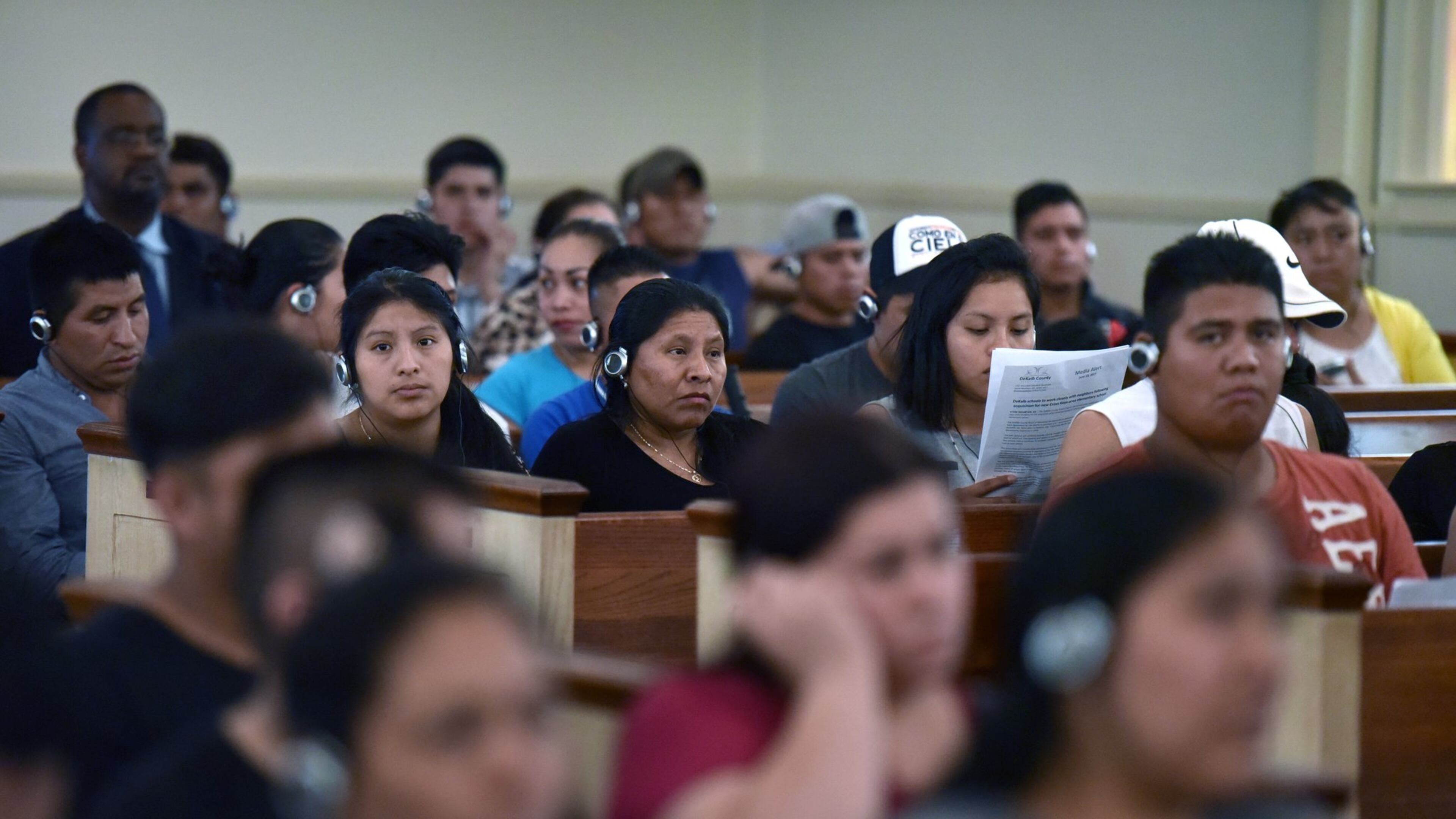 Residents of Shallowford Gardens Apartments listen to explanation of John Lantz, manger of Shallowford Gardens Apartments, through a translation system during a community meeting at First Baptist Church of Doraville on Wednesday, June 14, 2017. The DeKalb County School District late Monday approved buying that apartment complex, where it plans to build a new elementary school to alleviate overcrowding in the Cross Keys cluster of schools. Dozens of families in the 104-unit Shallowford Garden Apartments have until the end of August to find new housing. HYOSUB SHIN / HSHIN@AJC.COM