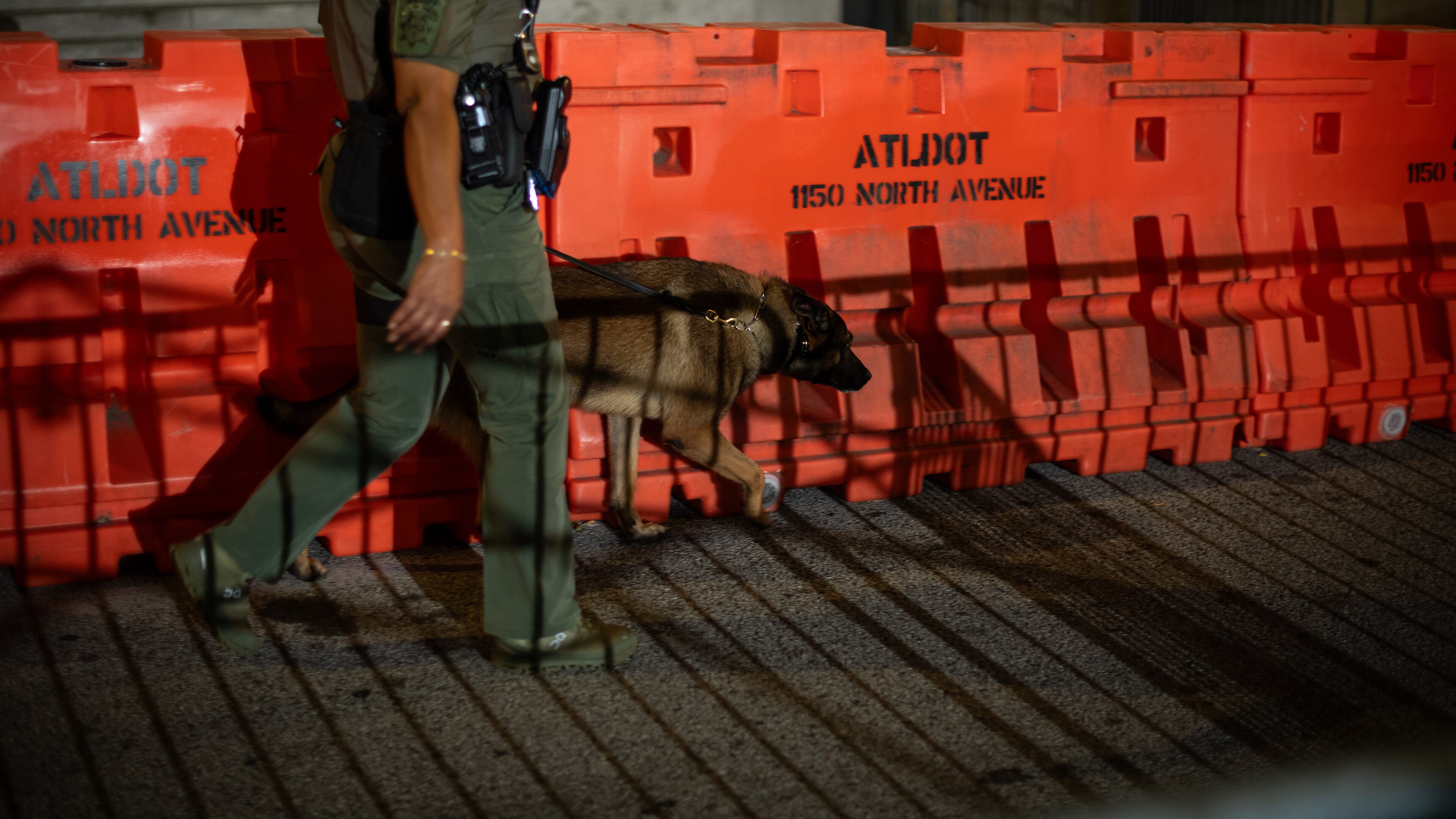 A deputy walks a barricade erected before dawn outside the Fulton County Courthouse in Atlanta, on Aug. 15, 2023. Police said Thursday that they were investigating online threats against the grand jurors who voted this week to indict Donald Trump and 18 others; the jurors’ names are public record under Georgia law. (Hilary Swift/The New York Times)