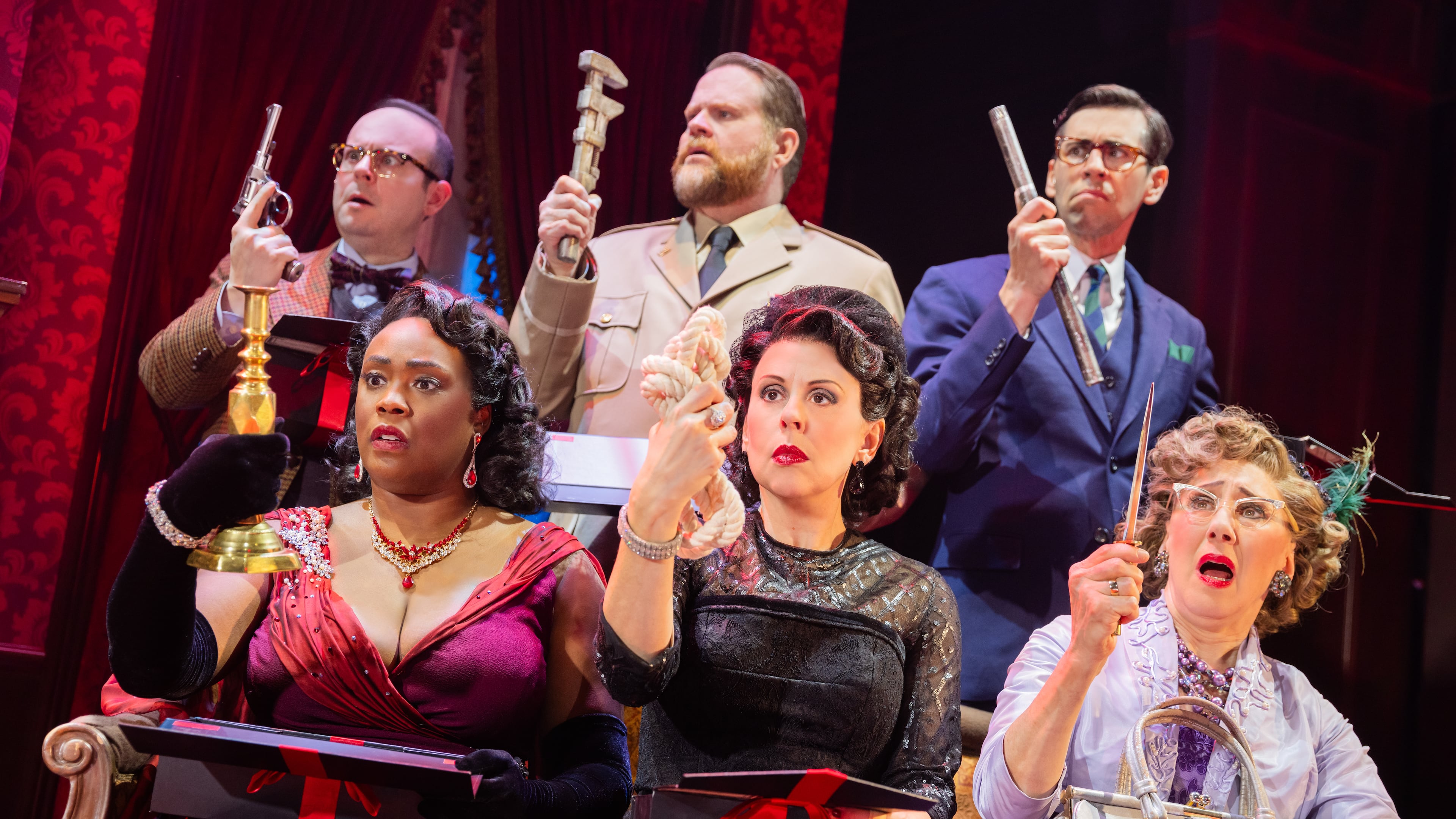 Characters from "Clue: Live on Stage!" hold up their respective murder weapons in the national touring production onstage at the Fox Theatre through Sunday.