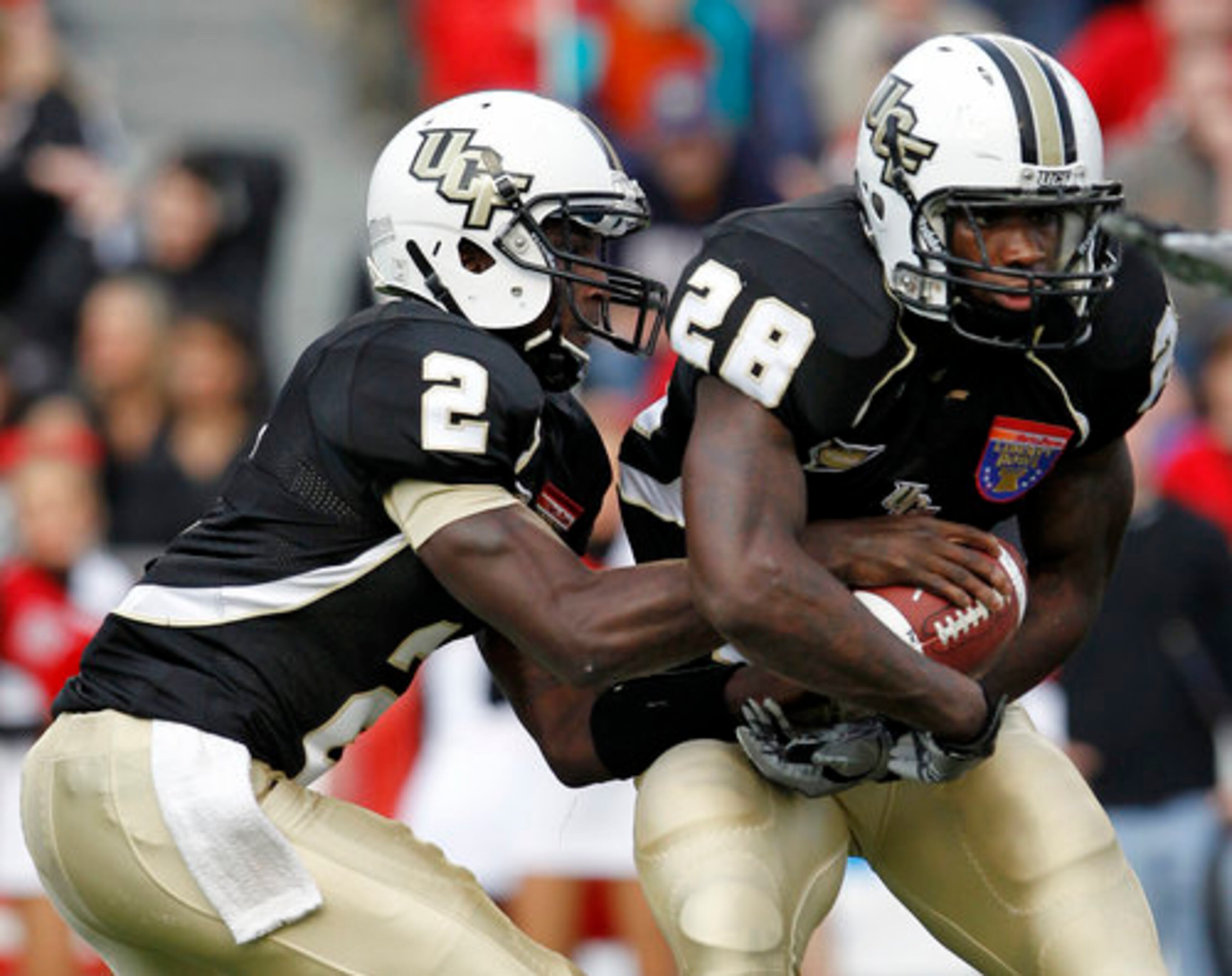 Central Florida quarterback Jeff Godfrey (2) fakes a handoff to running back Latavius Murray (28) in the first quarter of the Liberty Bowl NCAA college football game against Georgia on Friday, Dec. 31, 2010 in Memphis, Tenn.