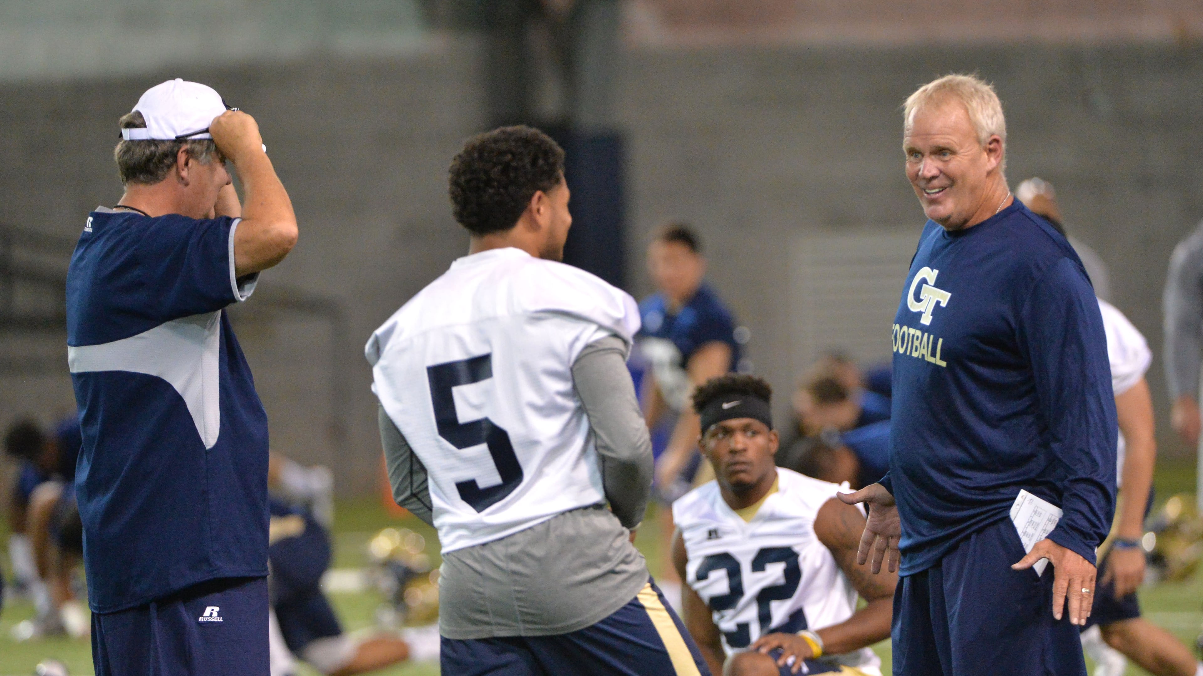 Georgia Tech quarterback Justin Thomas (5), chatting Friday on the first day of practice with safeties coach Andy McCollum, is one of five scholarship quarterbacks on the roster, unusual depth for the Yellow Jackets. HYOSUB SHIN / HSHIN@AJC.COM